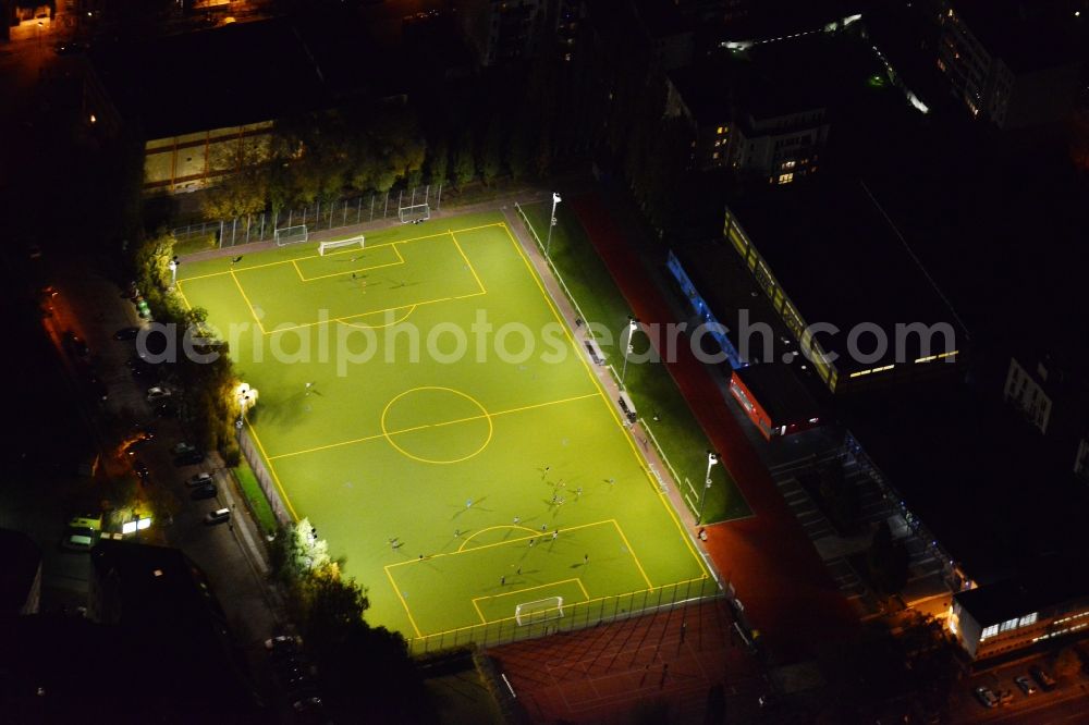 Berlin from above - Nightly lighted sports court - football field at the Hauffstrasse - Spirtastrasse in Rummelsburg district in Berlin