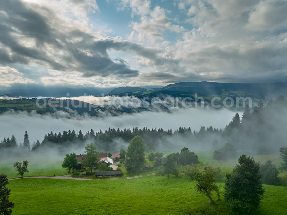 Irsengund from the bird's eye view: Weather related fog banks and cloud layer over forest and meadow landscape in Irsengund allgaeu in the state Bavaria, Germany