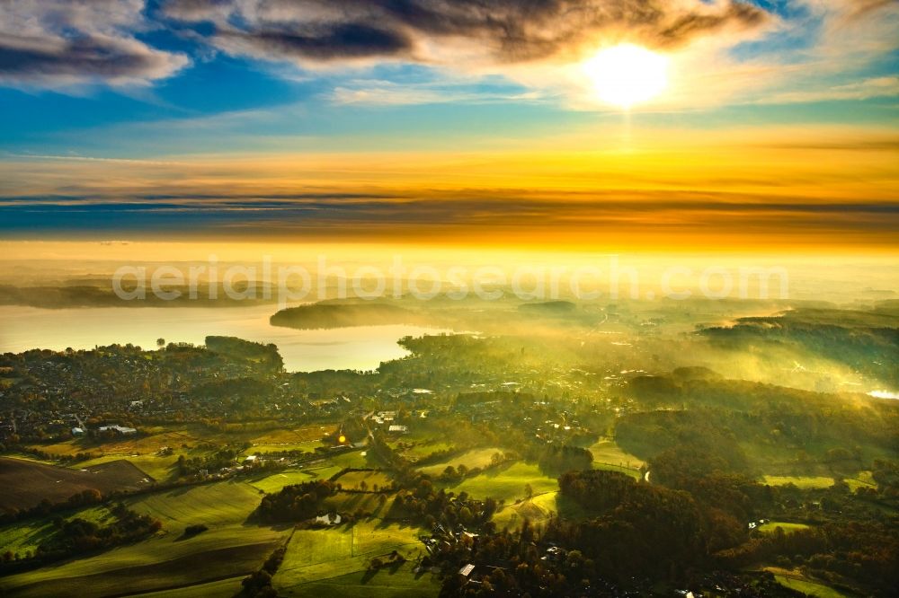 Malente from above - Weather related fog banks and cloud layer in Sonnenaufgang in Malente in the Holsteinische Schweiz in the state Schleswig-Holstein, Germany