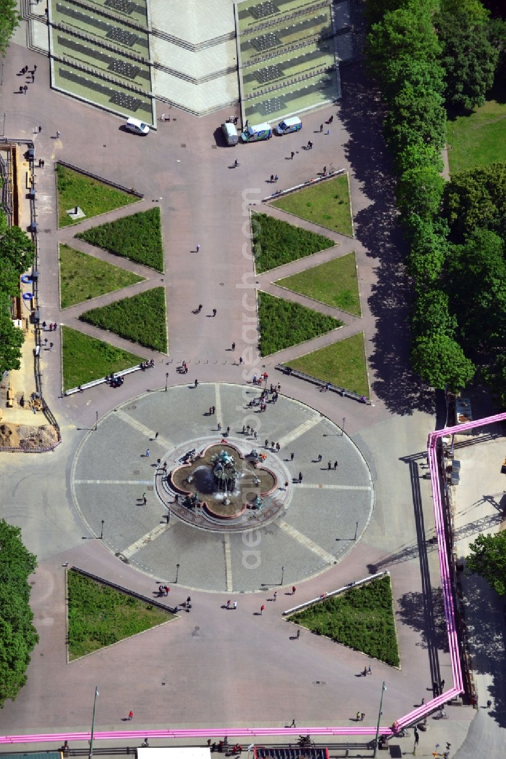 Aerial image Berlin - The Fountain of Neptune is a fountain on the Alexanderplatz in the Mitte district of Berlin. The fountain with the floor plans in the form of a clover leaf was designed by the artist Reinold Bega. In the center of the filigree and vibrant plastic is the sea god Neptune