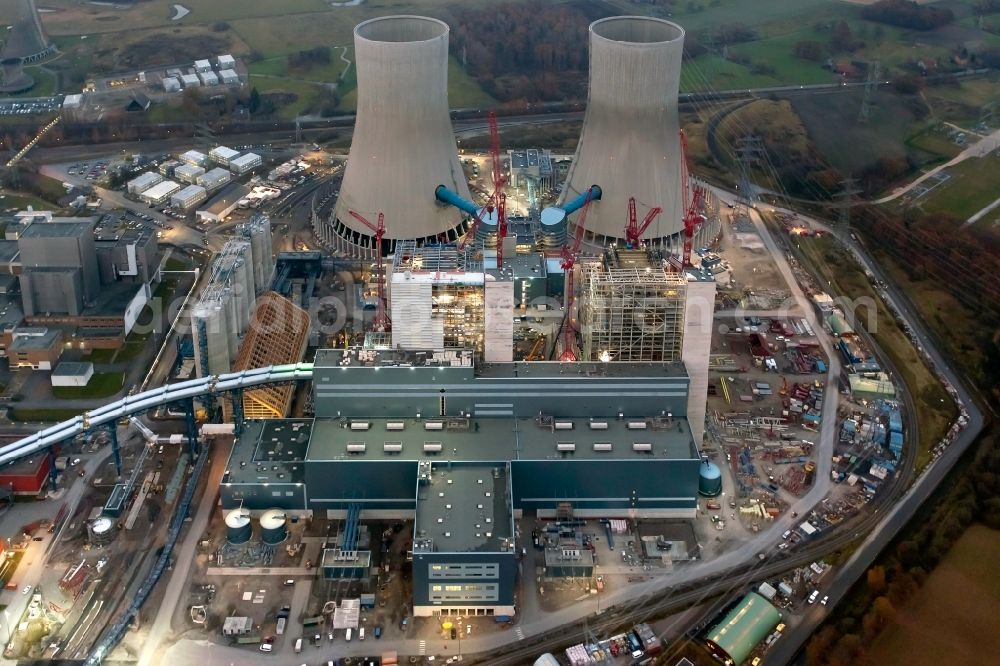 Hamm from the bird's eye view: Construction site of the Westfalen power plant at dusk. The coal-fired power plant of RWE in the Siegenbeckstrasse in Schmehausen district in Hamm in North Rhine-Westphalia is extended by the coal blocks D and E with two cooling towers