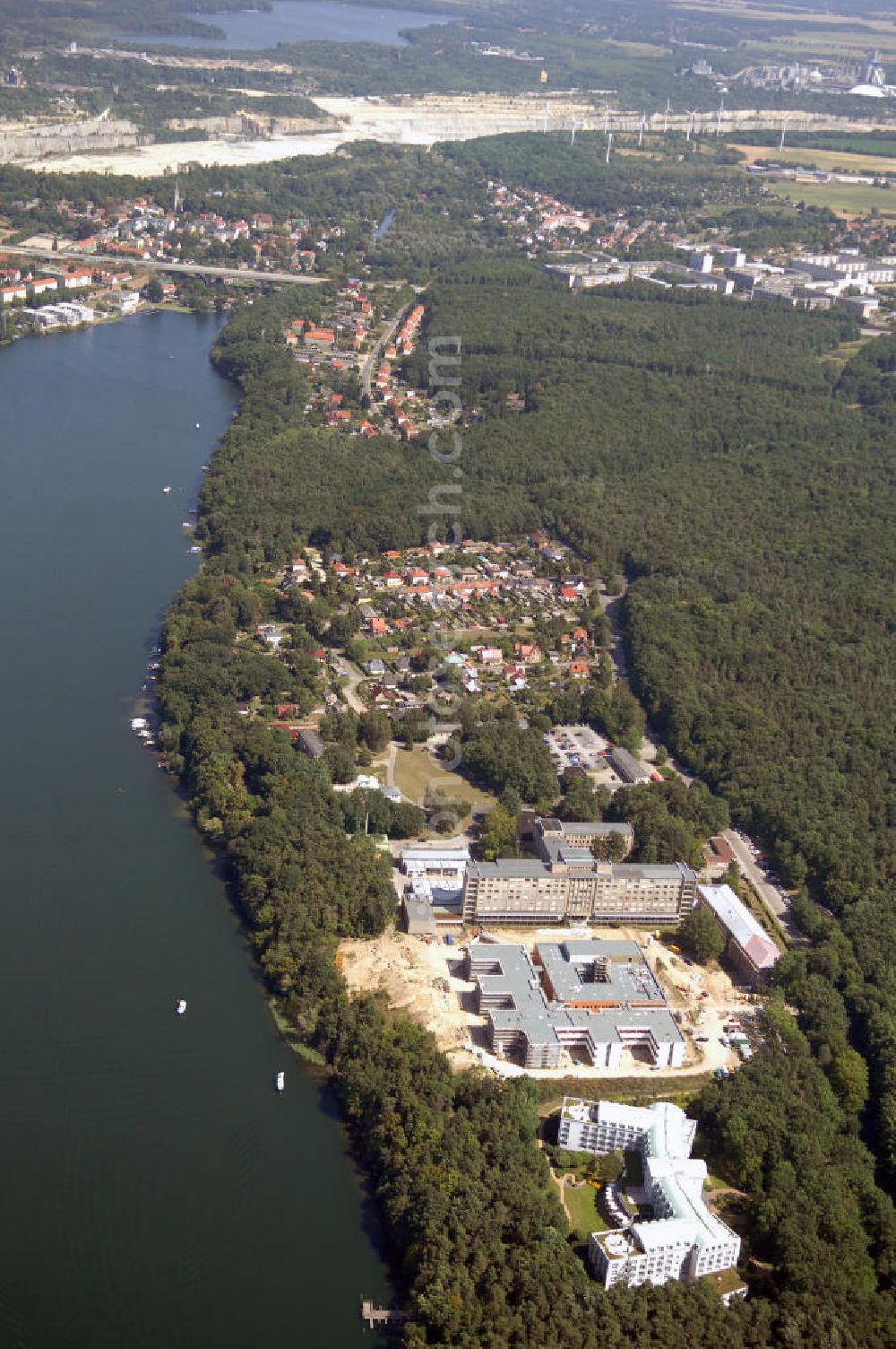 Aerial photograph Rüdersdorf - Blick über die Klinik am See, Rehabilitationszentrum für Innere Medizin, auf die Baustelle des Krankenhaus Neubaus des Evangelisch-Freikirchlichen Krankenhaus Rüdersdorf. Dahinter befindet sich das alte Bettenhaus mit sämtlichen Nebengebäuden aus den 60er-Jahren, welches nach dem Umzug in das neue Gebäude abgerissen wird. Auf dem Gelände wird dann der Park des Krankenhauses entstehen, u. a. mit einem Kinderspielplatz und Medizinalkräutergarten. Das neue drei- und viergeschossige Krankenhaus hat eine Kapazität für 287 Betten in 135 Patientenzimmern. Im Hintergrund die Rüdersdorfer Kalksteinbrüche. Kontakt: Krankenhaus und Poliklinik Rüdersdorf GmbH, Seebad 82/83, 15562 Rüdersdorf, Tel. +49(0)33638 83 0, Fax +49(0)33638 83 228, E-Mail: info @krankenhaus-ruedersdorf.de; Kontakt: Immanuel Diakonie GmbH (Holding), Am Kleinen Wannsee 5, 14109 Berlin, Tel. +490)30 80505 272, Fax +490)30 80505 266, E-Mail: mail@immanuel.de