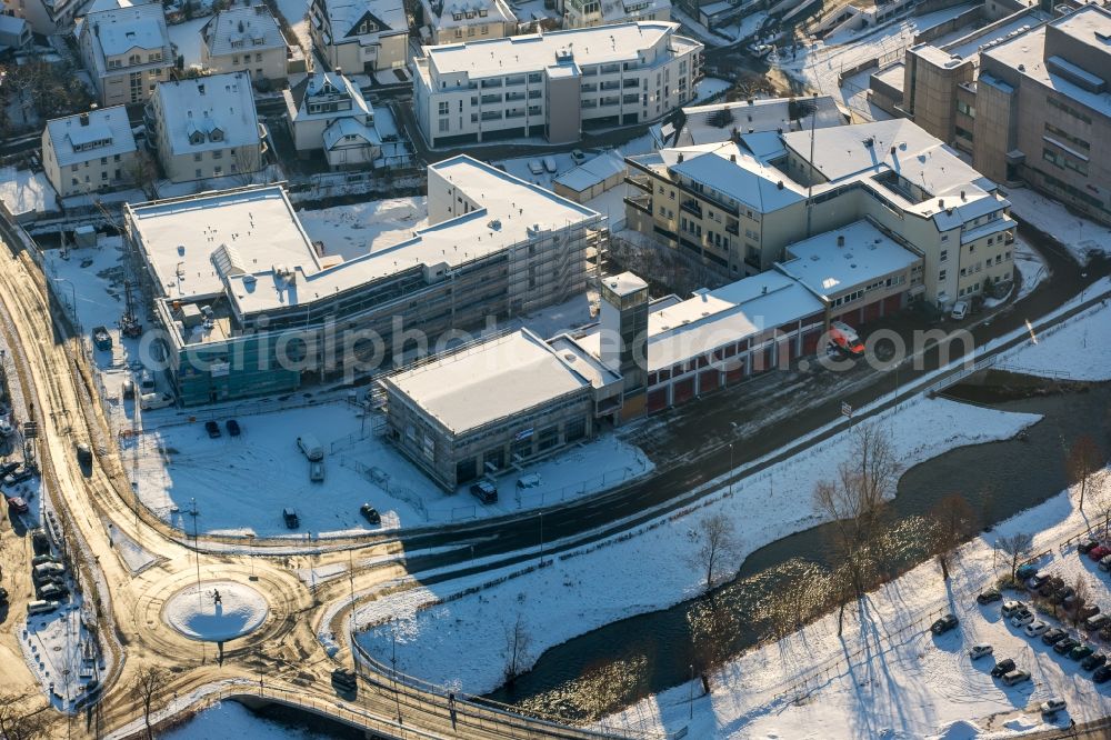 Meschede from the bird's eye view: Winterly snowy building of the retirement home Rinschen Park of the company Siedlungs- und Baugenossenschaft Meschede eG aswell as the building complex of the volunteer fire brigade of Meschede beneath the roads Fritz-Honsel-Strasse and Muehlenweg and the river Ruhr in Meschede in the state North Rhine-Westphalia