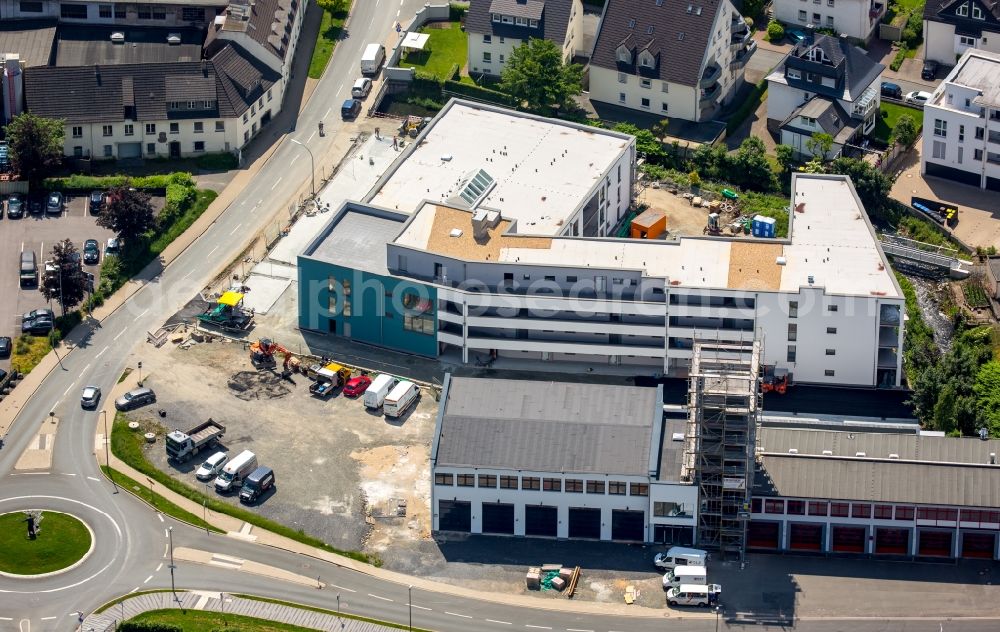 Meschede from the bird's eye view: Building of the retirement home Rinschen Park of the company Siedlungs- und Baugenossenschaft Meschede eG aswell as the building complex of the volunteer fire brigade of Meschede beneath the roads Fritz-Honsel-Strasse and Muehlenweg and the river Ruhr in Meschede in the state North Rhine-Westphalia