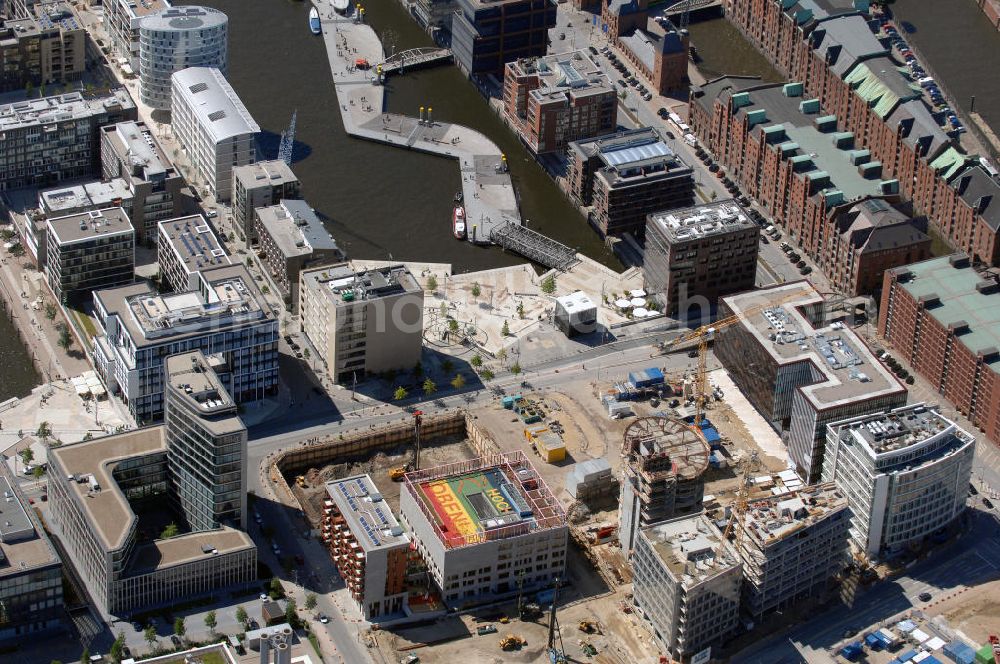 Hamburg from above - Blick auf den Naubau der HafenCity Schule in der neu entstehenden Hafen City Am Sandtorpark - Grasbrook auf dem Dalmannkai. Das Ensemble besteht aus einer Grundschule, einer Kindertagesstätte / Kita sowie 40 Wohnungen, auf dem Dach befindet sich ein Spielplatz / Pausenhof. Die HafenCity ist ein Hamburger Stadtteil im Bezirk Hamburg-Mitte. Der 155 Hektar große Stadtteil (mit 60 Hektar Nettobauland) soll neben Büroflächen für mehr als 40.000 Arbeitsplätze, die zu einem Teil schon fertiggestellt sind, auch Wohnraum für 12.000 Einwohner in 5.500 Wohnungen bieten und ist damit das größte laufende Vorhaben zur Stadtentwicklung von Hamburg. Allgemeine Informationen: