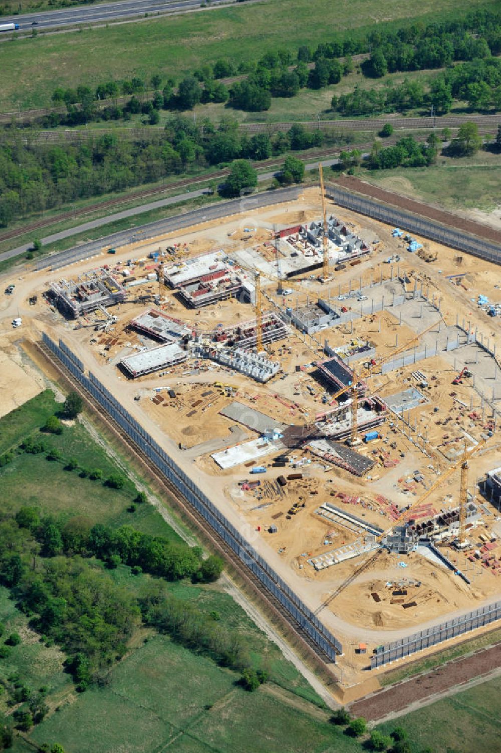 Großbeeren from the bird's eye view: Baustelle vom Neubau der Justizvollzugsanstalt JVA Heidering Großbeeren im Landkreis Teltow-Fläming in Brandenburg durch die Senatsverwaltung für Justiz. Der Neubau der Haftanstalt in Großbeeren wird nur elektrisch und mit einem Erdwall gesichert statt mit einer koventionellen Gefängnismauer. Die Projektentwurf erfolgte durch das Architekturbüro Hohensinn. Ausführende Baufirmen sind die Bleck & Söhne Hoch- und Tiefbau GmbH & Co. KG, sowie die Schälerbau Berlin. Construction site of the new penal institution Heidering Grossbeeren.