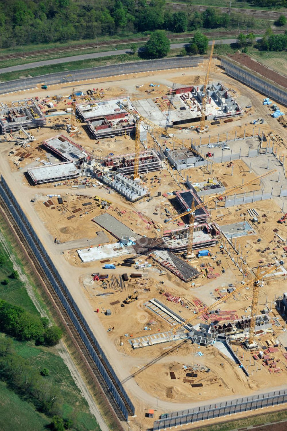 Aerial image Großbeeren - Baustelle vom Neubau der Justizvollzugsanstalt JVA Heidering Großbeeren im Landkreis Teltow-Fläming in Brandenburg durch die Senatsverwaltung für Justiz. Der Neubau der Haftanstalt in Großbeeren wird nur elektrisch und mit einem Erdwall gesichert statt mit einer koventionellen Gefängnismauer. Die Projektentwurf erfolgte durch das Architekturbüro Hohensinn. Ausführende Baufirmen sind die Bleck & Söhne Hoch- und Tiefbau GmbH & Co. KG, sowie die Schälerbau Berlin. Construction site of the new penal institution Heidering Grossbeeren.