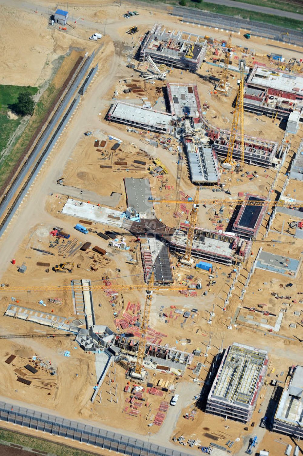 Aerial image Großbeeren - Baustelle vom Neubau der Justizvollzugsanstalt JVA Heidering Großbeeren im Landkreis Teltow-Fläming in Brandenburg durch die Senatsverwaltung für Justiz. Der Neubau der Haftanstalt in Großbeeren wird nur elektrisch und mit einem Erdwall gesichert statt mit einer koventionellen Gefängnismauer. Die Projektentwurf erfolgte durch das Architekturbüro Hohensinn. Ausführende Baufirmen sind die Bleck & Söhne Hoch- und Tiefbau GmbH & Co. KG, sowie die Schälerbau Berlin. Construction site of the new penal institution Heidering Grossbeeren.