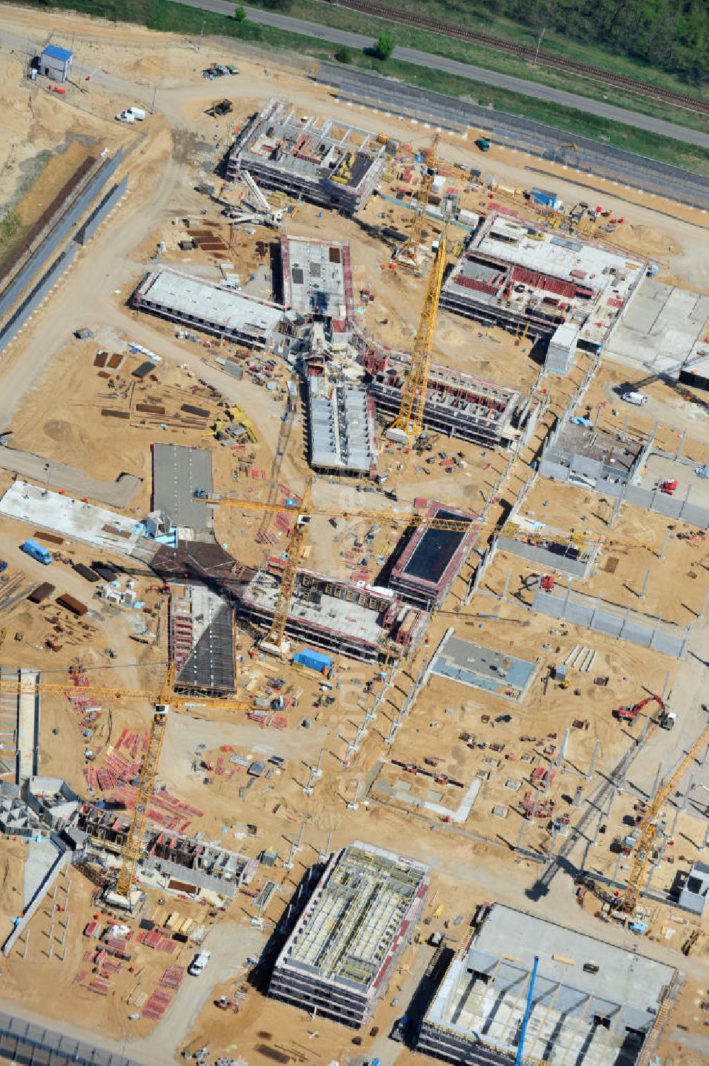 Aerial photograph Großbeeren - Baustelle vom Neubau der Justizvollzugsanstalt JVA Heidering Großbeeren im Landkreis Teltow-Fläming in Brandenburg durch die Senatsverwaltung für Justiz. Der Neubau der Haftanstalt in Großbeeren wird nur elektrisch und mit einem Erdwall gesichert statt mit einer koventionellen Gefängnismauer. Die Projektentwurf erfolgte durch das Architekturbüro Hohensinn. Ausführende Baufirmen sind die Bleck & Söhne Hoch- und Tiefbau GmbH & Co. KG, sowie die Schälerbau Berlin. Construction site of the new penal institution Heidering Grossbeeren.