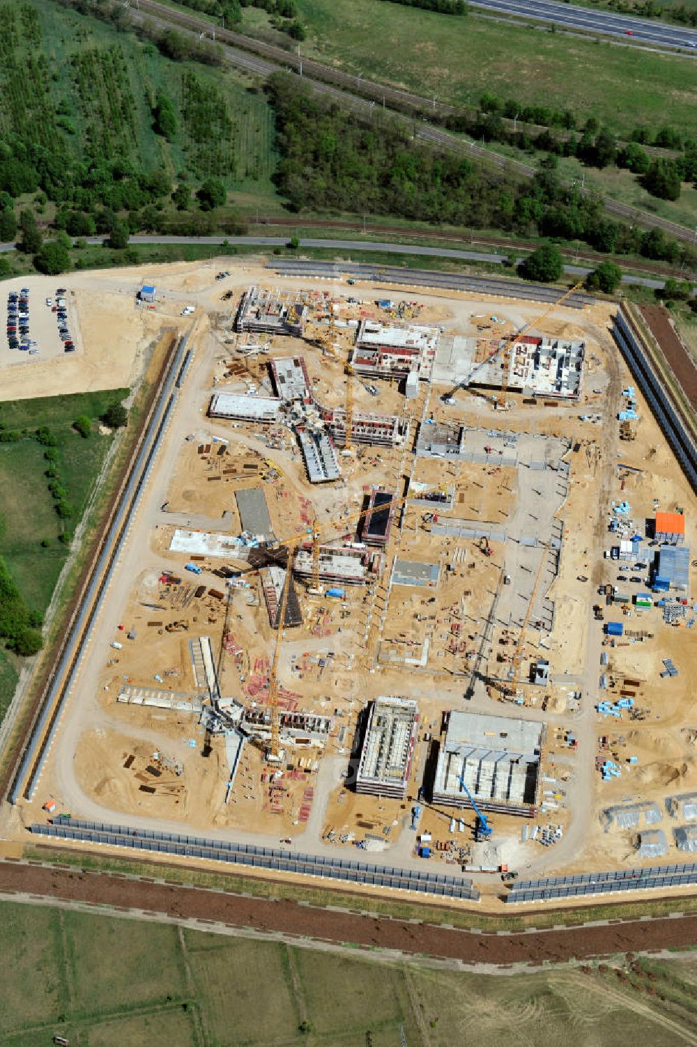 Großbeeren from the bird's eye view: Baustelle vom Neubau der Justizvollzugsanstalt JVA Heidering Großbeeren im Landkreis Teltow-Fläming in Brandenburg durch die Senatsverwaltung für Justiz. Der Neubau der Haftanstalt in Großbeeren wird nur elektrisch und mit einem Erdwall gesichert statt mit einer koventionellen Gefängnismauer. Die Projektentwurf erfolgte durch das Architekturbüro Hohensinn. Ausführende Baufirmen sind die Bleck & Söhne Hoch- und Tiefbau GmbH & Co. KG, sowie die Schälerbau Berlin. Construction site of the new penal institution Heidering Grossbeeren.