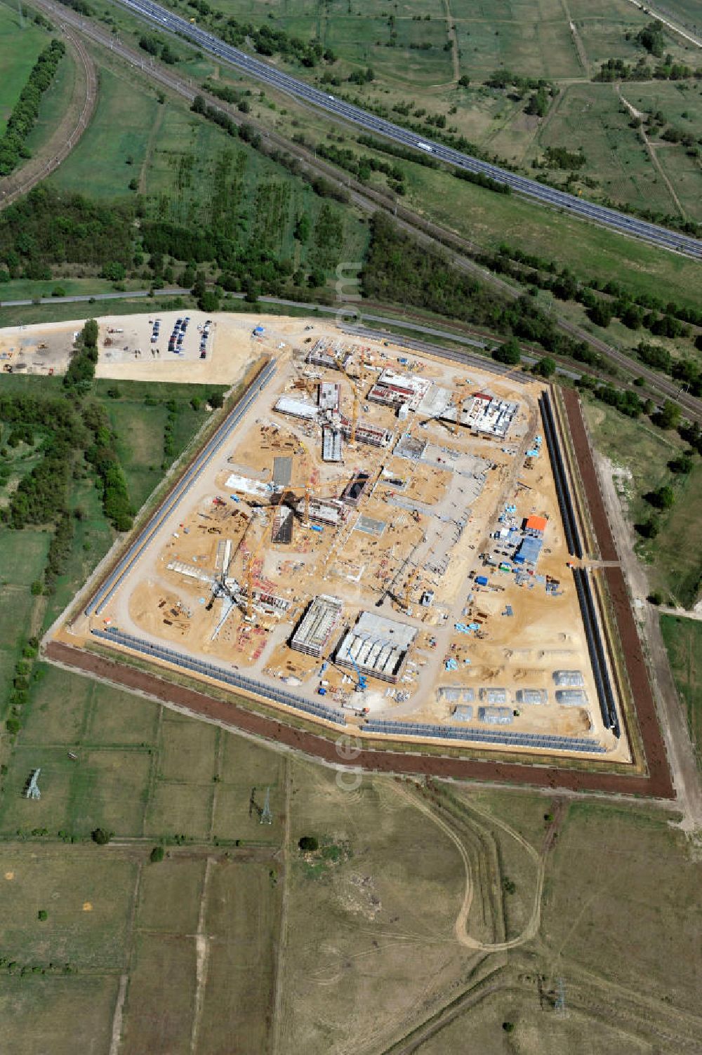 Aerial image Großbeeren - Baustelle vom Neubau der Justizvollzugsanstalt JVA Heidering Großbeeren im Landkreis Teltow-Fläming in Brandenburg durch die Senatsverwaltung für Justiz. Der Neubau der Haftanstalt in Großbeeren wird nur elektrisch und mit einem Erdwall gesichert statt mit einer koventionellen Gefängnismauer. Die Projektentwurf erfolgte durch das Architekturbüro Hohensinn. Ausführende Baufirmen sind die Bleck & Söhne Hoch- und Tiefbau GmbH & Co. KG, sowie die Schälerbau Berlin. Construction site of the new penal institution Heidering Grossbeeren.