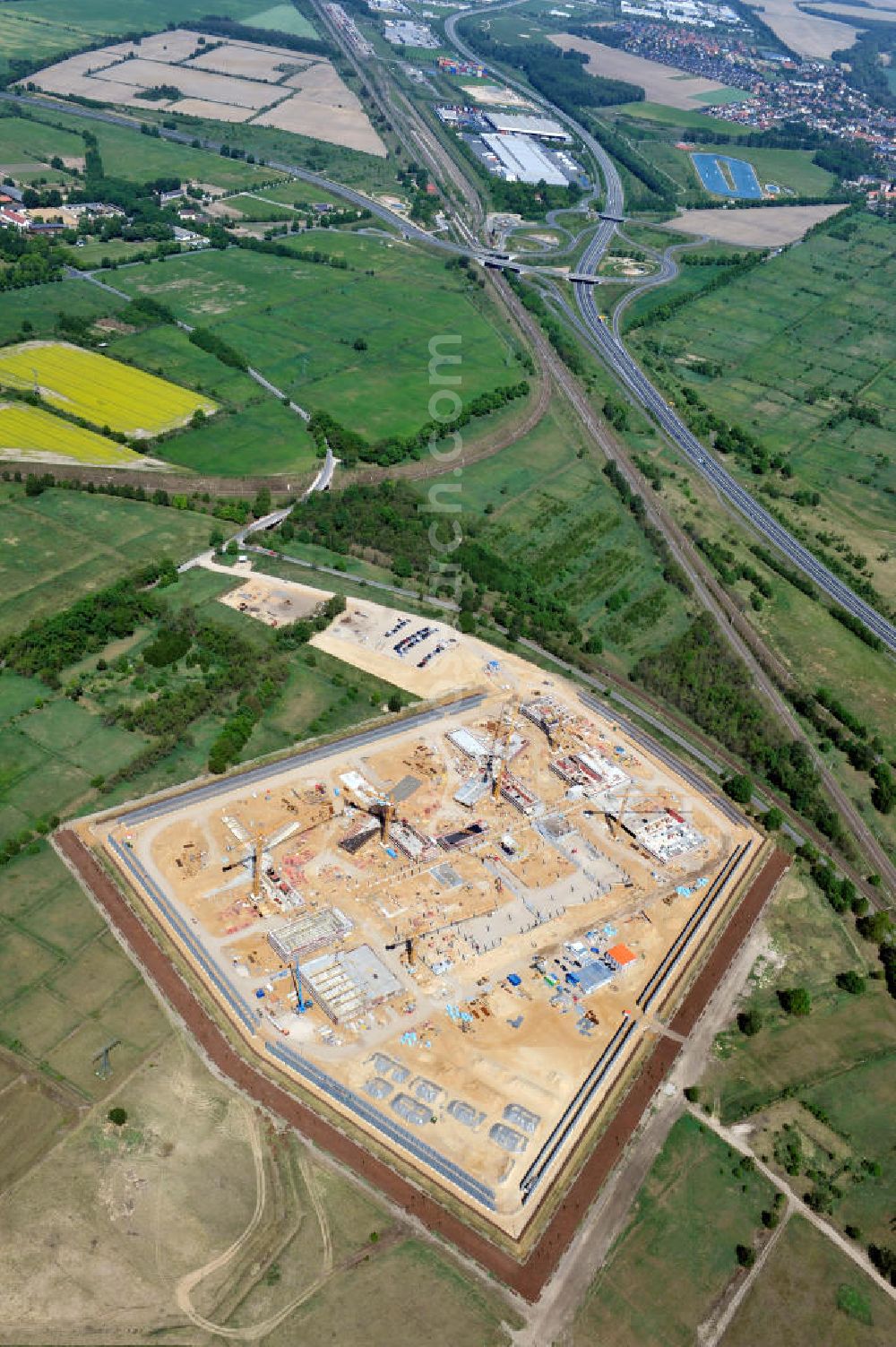 Aerial photograph Großbeeren - Baustelle vom Neubau der Justizvollzugsanstalt JVA Heidering Großbeeren im Landkreis Teltow-Fläming in Brandenburg durch die Senatsverwaltung für Justiz. Der Neubau der Haftanstalt in Großbeeren wird nur elektrisch und mit einem Erdwall gesichert statt mit einer koventionellen Gefängnismauer. Die Projektentwurf erfolgte durch das Architekturbüro Hohensinn. Ausführende Baufirmen sind die Bleck & Söhne Hoch- und Tiefbau GmbH & Co. KG, sowie die Schälerbau Berlin. Construction site of the new penal institution Heidering Grossbeeren.