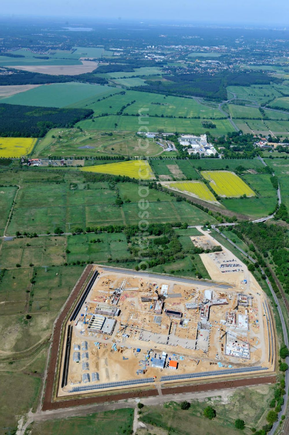 Großbeeren from the bird's eye view: Baustelle vom Neubau der Justizvollzugsanstalt JVA Heidering Großbeeren im Landkreis Teltow-Fläming in Brandenburg durch die Senatsverwaltung für Justiz. Der Neubau der Haftanstalt in Großbeeren wird nur elektrisch und mit einem Erdwall gesichert statt mit einer koventionellen Gefängnismauer. Die Projektentwurf erfolgte durch das Architekturbüro Hohensinn. Ausführende Baufirmen sind die Bleck & Söhne Hoch- und Tiefbau GmbH & Co. KG, sowie die Schälerbau Berlin. Construction site of the new penal institution Heidering Grossbeeren.