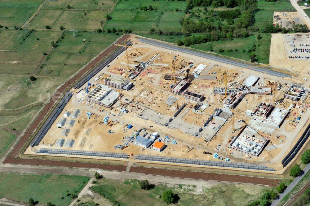 Aerial photograph Großbeeren - Baustelle vom Neubau der Justizvollzugsanstalt JVA Heidering Großbeeren im Landkreis Teltow-Fläming in Brandenburg durch die Senatsverwaltung für Justiz. Der Neubau der Haftanstalt in Großbeeren wird nur elektrisch und mit einem Erdwall gesichert statt mit einer koventionellen Gefängnismauer. Die Projektentwurf erfolgte durch das Architekturbüro Hohensinn. Ausführende Baufirmen sind die Bleck & Söhne Hoch- und Tiefbau GmbH & Co. KG, sowie die Schälerbau Berlin. Construction site of the new penal institution Heidering Grossbeeren.