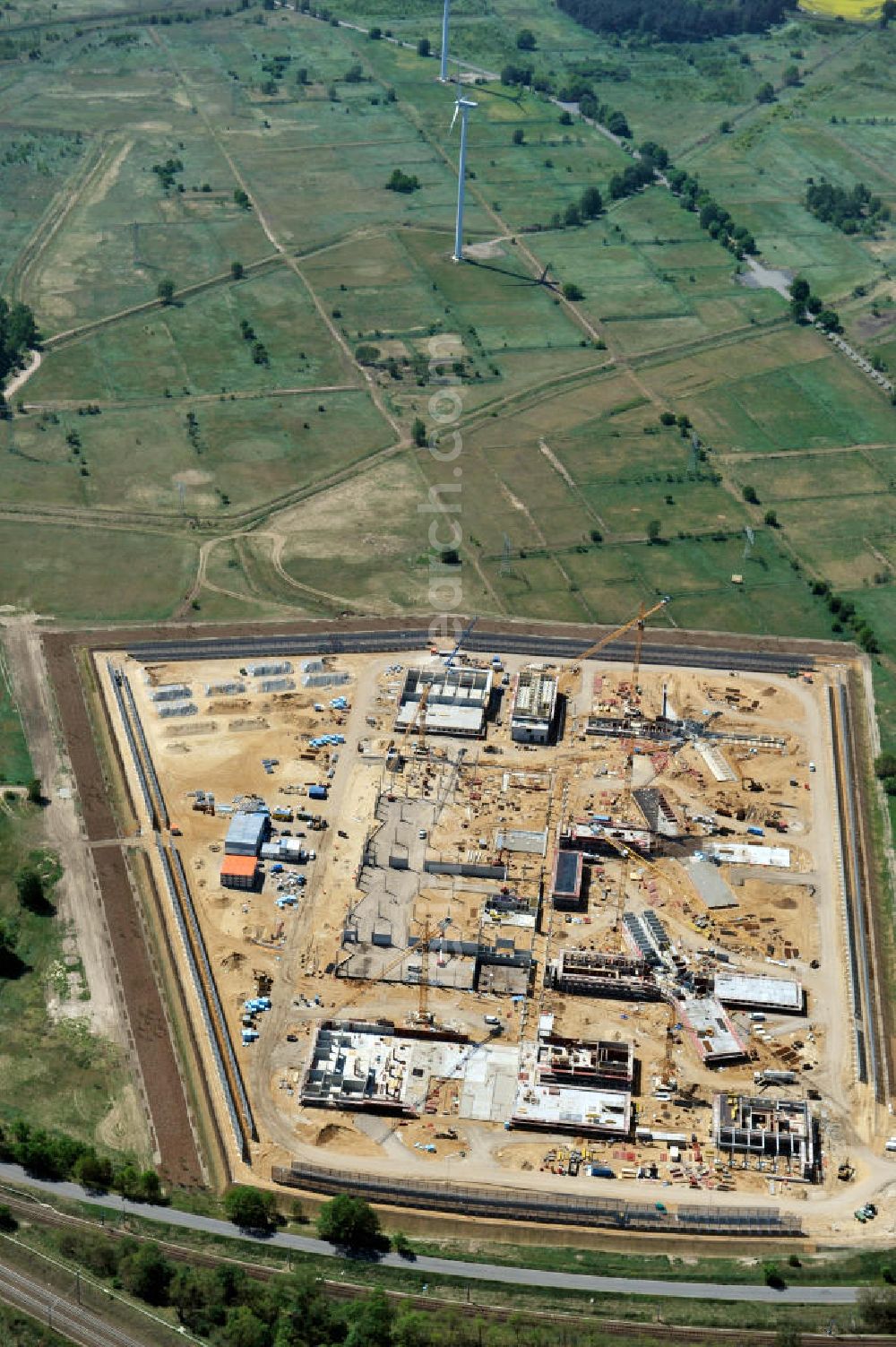 Aerial image Großbeeren - Baustelle vom Neubau der Justizvollzugsanstalt JVA Heidering Großbeeren im Landkreis Teltow-Fläming in Brandenburg durch die Senatsverwaltung für Justiz. Der Neubau der Haftanstalt in Großbeeren wird nur elektrisch und mit einem Erdwall gesichert statt mit einer koventionellen Gefängnismauer. Die Projektentwurf erfolgte durch das Architekturbüro Hohensinn. Ausführende Baufirmen sind die Bleck & Söhne Hoch- und Tiefbau GmbH & Co. KG, sowie die Schälerbau Berlin. Construction site of the new penal institution Heidering Grossbeeren.