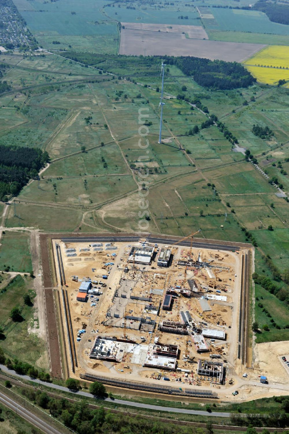 Aerial photograph Großbeeren - Baustelle vom Neubau der Justizvollzugsanstalt JVA Heidering Großbeeren im Landkreis Teltow-Fläming in Brandenburg durch die Senatsverwaltung für Justiz. Der Neubau der Haftanstalt in Großbeeren wird nur elektrisch und mit einem Erdwall gesichert statt mit einer koventionellen Gefängnismauer. Die Projektentwurf erfolgte durch das Architekturbüro Hohensinn. Ausführende Baufirmen sind die Bleck & Söhne Hoch- und Tiefbau GmbH & Co. KG, sowie die Schälerbau Berlin. Construction site of the new penal institution Heidering Grossbeeren.