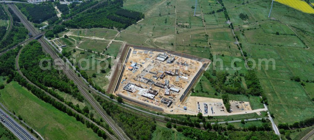 Großbeeren from the bird's eye view: Baustelle vom Neubau der Justizvollzugsanstalt JVA Heidering Großbeeren im Landkreis Teltow-Fläming in Brandenburg durch die Senatsverwaltung für Justiz. Der Neubau der Haftanstalt in Großbeeren wird nur elektrisch und mit einem Erdwall gesichert statt mit einer koventionellen Gefängnismauer. Die Projektentwurf erfolgte durch das Architekturbüro Hohensinn. Ausführende Baufirmen sind die Bleck & Söhne Hoch- und Tiefbau GmbH & Co. KG, sowie die Schälerbau Berlin. Construction site of the new penal institution Heidering Grossbeeren.