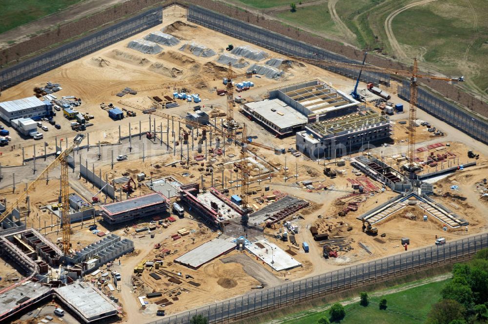 Aerial photograph Großbeeren - Baustelle vom Neubau der Justizvollzugsanstalt JVA Heidering Großbeeren im Landkreis Teltow-Fläming in Brandenburg durch die Senatsverwaltung für Justiz. Der Neubau der Haftanstalt in Großbeeren wird nur elektrisch und mit einem Erdwall gesichert statt mit einer koventionellen Gefängnismauer. Die Projektentwurf erfolgte durch das Architekturbüro Hohensinn. Ausführende Baufirmen sind die Bleck & Söhne Hoch- und Tiefbau GmbH & Co. KG, sowie die Schälerbau Berlin. Construction site of the new penal institution Heidering Grossbeeren.