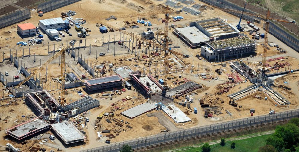 Großbeeren from above - Baustelle vom Neubau der Justizvollzugsanstalt JVA Heidering Großbeeren im Landkreis Teltow-Fläming in Brandenburg durch die Senatsverwaltung für Justiz. Der Neubau der Haftanstalt in Großbeeren wird nur elektrisch und mit einem Erdwall gesichert statt mit einer koventionellen Gefängnismauer. Die Projektentwurf erfolgte durch das Architekturbüro Hohensinn. Ausführende Baufirmen sind die Bleck & Söhne Hoch- und Tiefbau GmbH & Co. KG, sowie die Schälerbau Berlin. Construction site of the new penal institution Heidering Grossbeeren.