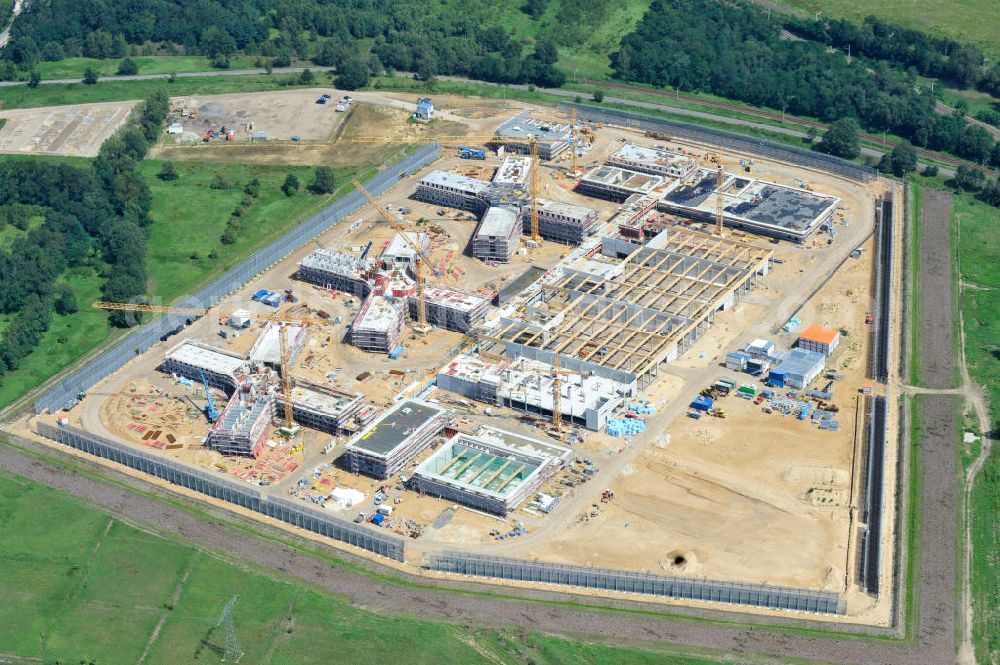 Großbeeren from the bird's eye view: Baustelle vom Neubau der Justizvollzugsanstalt JVA Heidering Großbeeren im Landkreis Teltow-Fläming in Brandenburg durch die Senatsverwaltung für Justiz. Der Neubau der Haftanstalt in Großbeeren wird nur elektrisch und mit einem Erdwall gesichert statt mit einer koventionellen Gefängnismauer. Die Projektentwurf erfolgte durch das Architekturbüro Hohensinn. Ausführende Baufirmen sind die Bleck & Söhne Hoch- und Tiefbau GmbH & Co. KG, sowie die Schälerbau Berlin. Construction site of the new penal institution Heidering Grossbeeren.