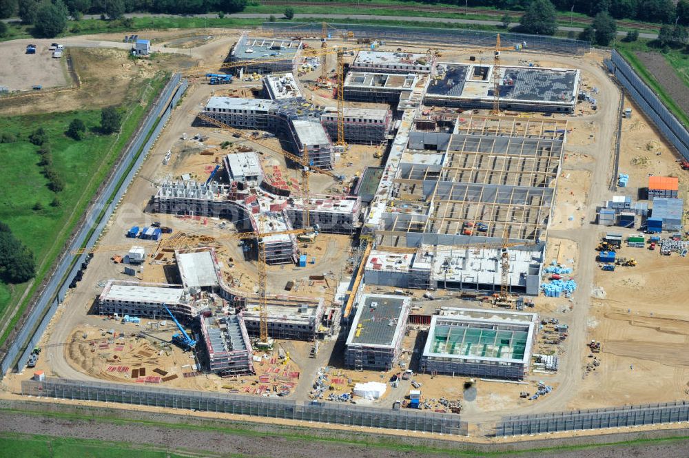 Großbeeren from the bird's eye view: Baustelle vom Neubau der Justizvollzugsanstalt JVA Heidering Großbeeren im Landkreis Teltow-Fläming in Brandenburg durch die Senatsverwaltung für Justiz. Der Neubau der Haftanstalt in Großbeeren wird nur elektrisch und mit einem Erdwall gesichert statt mit einer koventionellen Gefängnismauer. Die Projektentwurf erfolgte durch das Architekturbüro Hohensinn. Ausführende Baufirmen sind die Bleck & Söhne Hoch- und Tiefbau GmbH & Co. KG, sowie die Schälerbau Berlin. Construction site of the new penal institution Heidering Grossbeeren.