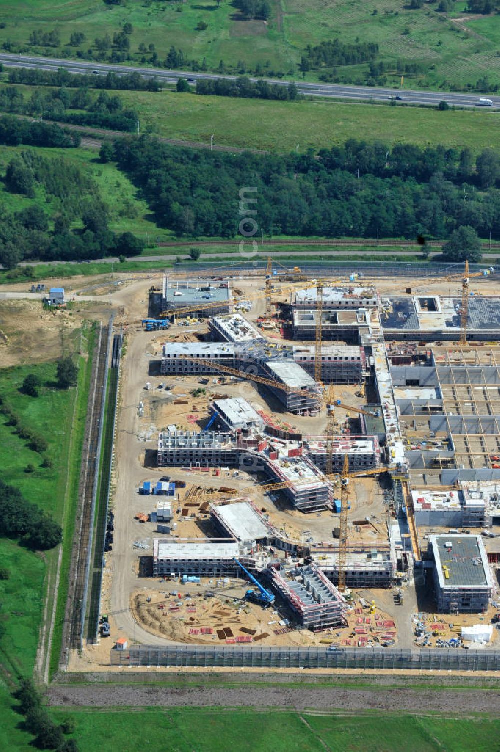 Aerial photograph Großbeeren - Baustelle vom Neubau der Justizvollzugsanstalt JVA Heidering Großbeeren im Landkreis Teltow-Fläming in Brandenburg durch die Senatsverwaltung für Justiz. Der Neubau der Haftanstalt in Großbeeren wird nur elektrisch und mit einem Erdwall gesichert statt mit einer koventionellen Gefängnismauer. Die Projektentwurf erfolgte durch das Architekturbüro Hohensinn. Ausführende Baufirmen sind die Bleck & Söhne Hoch- und Tiefbau GmbH & Co. KG, sowie die Schälerbau Berlin. Construction site of the new penal institution Heidering Grossbeeren.