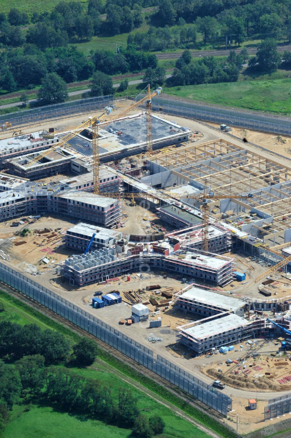 Großbeeren from above - Baustelle vom Neubau der Justizvollzugsanstalt JVA Heidering Großbeeren im Landkreis Teltow-Fläming in Brandenburg durch die Senatsverwaltung für Justiz. Der Neubau der Haftanstalt in Großbeeren wird nur elektrisch und mit einem Erdwall gesichert statt mit einer koventionellen Gefängnismauer. Die Projektentwurf erfolgte durch das Architekturbüro Hohensinn. Ausführende Baufirmen sind die Bleck & Söhne Hoch- und Tiefbau GmbH & Co. KG, sowie die Schälerbau Berlin. Construction site of the new penal institution Heidering Grossbeeren.