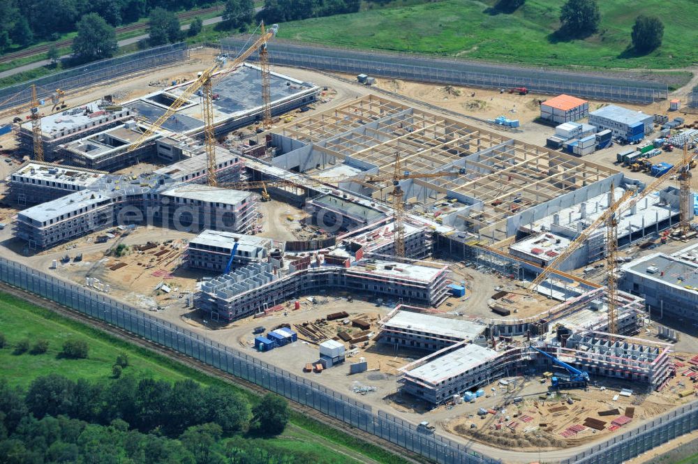 Großbeeren from the bird's eye view: Baustelle vom Neubau der Justizvollzugsanstalt JVA Heidering Großbeeren im Landkreis Teltow-Fläming in Brandenburg durch die Senatsverwaltung für Justiz. Der Neubau der Haftanstalt in Großbeeren wird nur elektrisch und mit einem Erdwall gesichert statt mit einer koventionellen Gefängnismauer. Die Projektentwurf erfolgte durch das Architekturbüro Hohensinn. Ausführende Baufirmen sind die Bleck & Söhne Hoch- und Tiefbau GmbH & Co. KG, sowie die Schälerbau Berlin. Construction site of the new penal institution Heidering Grossbeeren.