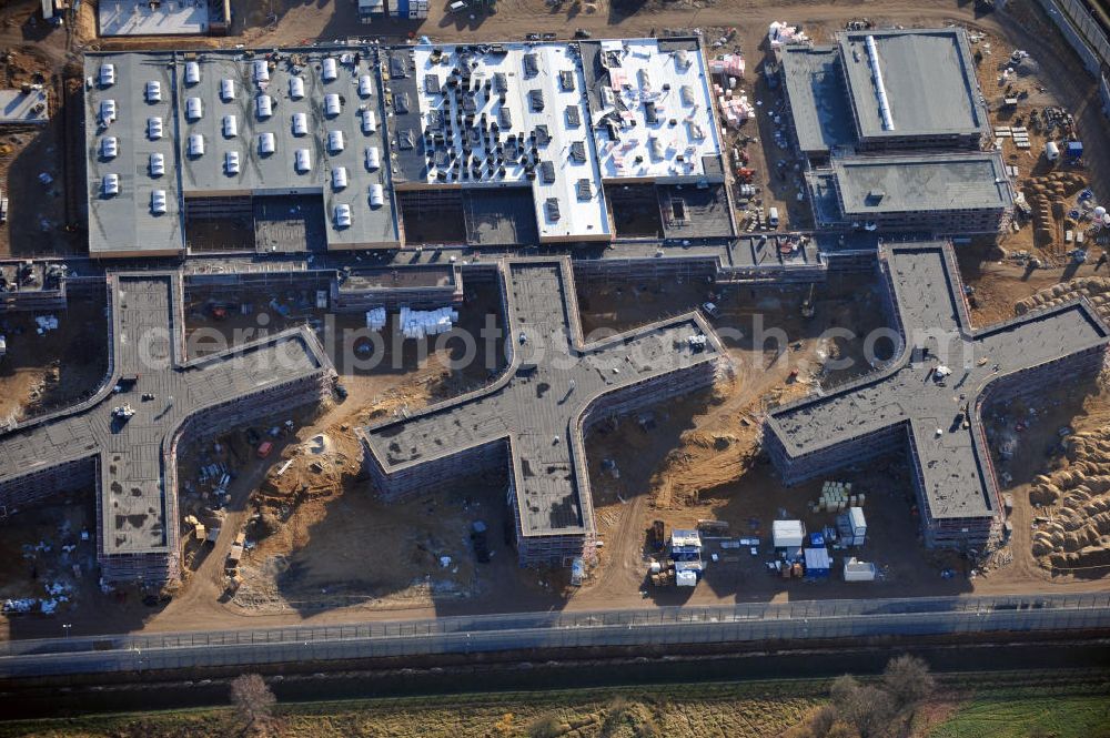 Aerial photograph Großbeeren - Baustelle vom Neubau der Justizvollzugsanstalt JVA Heidering Großbeeren im Landkreis Teltow-Fläming in Brandenburg durch die Senatsverwaltung für Justiz. Der Neubau der Haftanstalt in Großbeeren wird nur elektrisch und mit einem Erdwall gesichert statt mit einer koventionellen Gefängnismauer. Die Projektentwurf erfolgte durch das Architekturbüro Hohensinn. Ausführende Baufirmen sind die Bleck & Söhne Hoch- und Tiefbau GmbH & Co. KG, sowie die Schälerbau Berlin. Construction site of the new penal institution Heidering Grossbeeren.