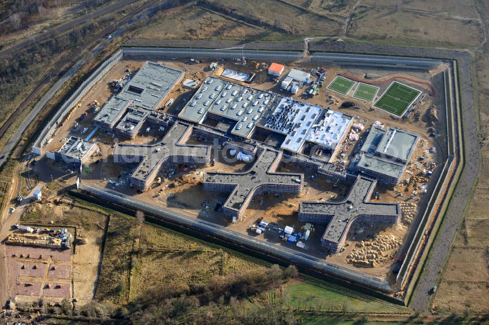 Großbeeren from above - Baustelle vom Neubau der Justizvollzugsanstalt JVA Heidering Großbeeren im Landkreis Teltow-Fläming in Brandenburg durch die Senatsverwaltung für Justiz. Der Neubau der Haftanstalt in Großbeeren wird nur elektrisch und mit einem Erdwall gesichert statt mit einer koventionellen Gefängnismauer. Die Projektentwurf erfolgte durch das Architekturbüro Hohensinn. Ausführende Baufirmen sind die Bleck & Söhne Hoch- und Tiefbau GmbH & Co. KG, sowie die Schälerbau Berlin. Construction site of the new penal institution Heidering Grossbeeren.