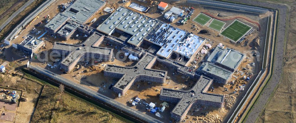 Großbeeren from the bird's eye view: Baustelle vom Neubau der Justizvollzugsanstalt JVA Heidering Großbeeren im Landkreis Teltow-Fläming in Brandenburg durch die Senatsverwaltung für Justiz. Der Neubau der Haftanstalt in Großbeeren wird nur elektrisch und mit einem Erdwall gesichert statt mit einer koventionellen Gefängnismauer. Die Projektentwurf erfolgte durch das Architekturbüro Hohensinn. Ausführende Baufirmen sind die Bleck & Söhne Hoch- und Tiefbau GmbH & Co. KG, sowie die Schälerbau Berlin. Construction site of the new penal institution Heidering Grossbeeren.