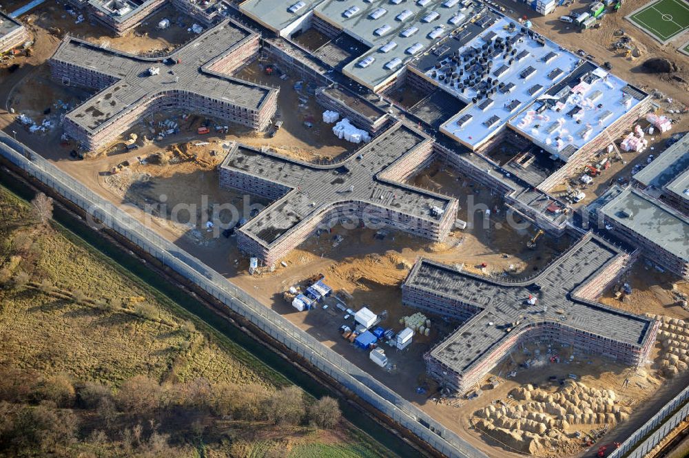 Aerial photograph Großbeeren - Baustelle vom Neubau der Justizvollzugsanstalt JVA Heidering Großbeeren im Landkreis Teltow-Fläming in Brandenburg durch die Senatsverwaltung für Justiz. Der Neubau der Haftanstalt in Großbeeren wird nur elektrisch und mit einem Erdwall gesichert statt mit einer koventionellen Gefängnismauer. Die Projektentwurf erfolgte durch das Architekturbüro Hohensinn. Ausführende Baufirmen sind die Bleck & Söhne Hoch- und Tiefbau GmbH & Co. KG, sowie die Schälerbau Berlin. Construction site of the new penal institution Heidering Grossbeeren.