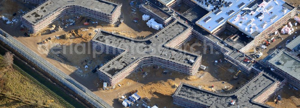 Großbeeren from above - Baustelle vom Neubau der Justizvollzugsanstalt JVA Heidering Großbeeren im Landkreis Teltow-Fläming in Brandenburg durch die Senatsverwaltung für Justiz. Der Neubau der Haftanstalt in Großbeeren wird nur elektrisch und mit einem Erdwall gesichert statt mit einer koventionellen Gefängnismauer. Die Projektentwurf erfolgte durch das Architekturbüro Hohensinn. Ausführende Baufirmen sind die Bleck & Söhne Hoch- und Tiefbau GmbH & Co. KG, sowie die Schälerbau Berlin. Construction site of the new penal institution Heidering Grossbeeren.