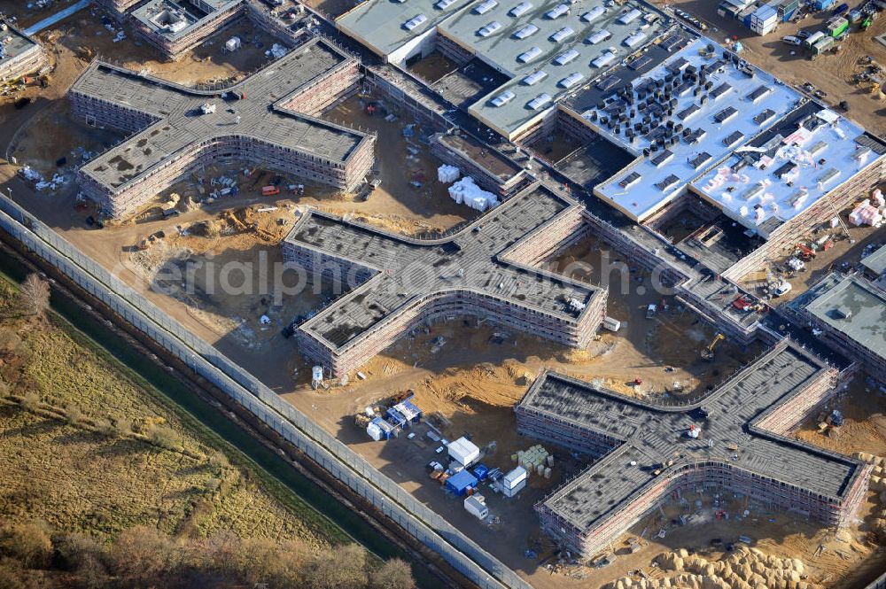 Großbeeren from the bird's eye view: Baustelle vom Neubau der Justizvollzugsanstalt JVA Heidering Großbeeren im Landkreis Teltow-Fläming in Brandenburg durch die Senatsverwaltung für Justiz. Der Neubau der Haftanstalt in Großbeeren wird nur elektrisch und mit einem Erdwall gesichert statt mit einer koventionellen Gefängnismauer. Die Projektentwurf erfolgte durch das Architekturbüro Hohensinn. Ausführende Baufirmen sind die Bleck & Söhne Hoch- und Tiefbau GmbH & Co. KG, sowie die Schälerbau Berlin. Construction site of the new penal institution Heidering Grossbeeren.