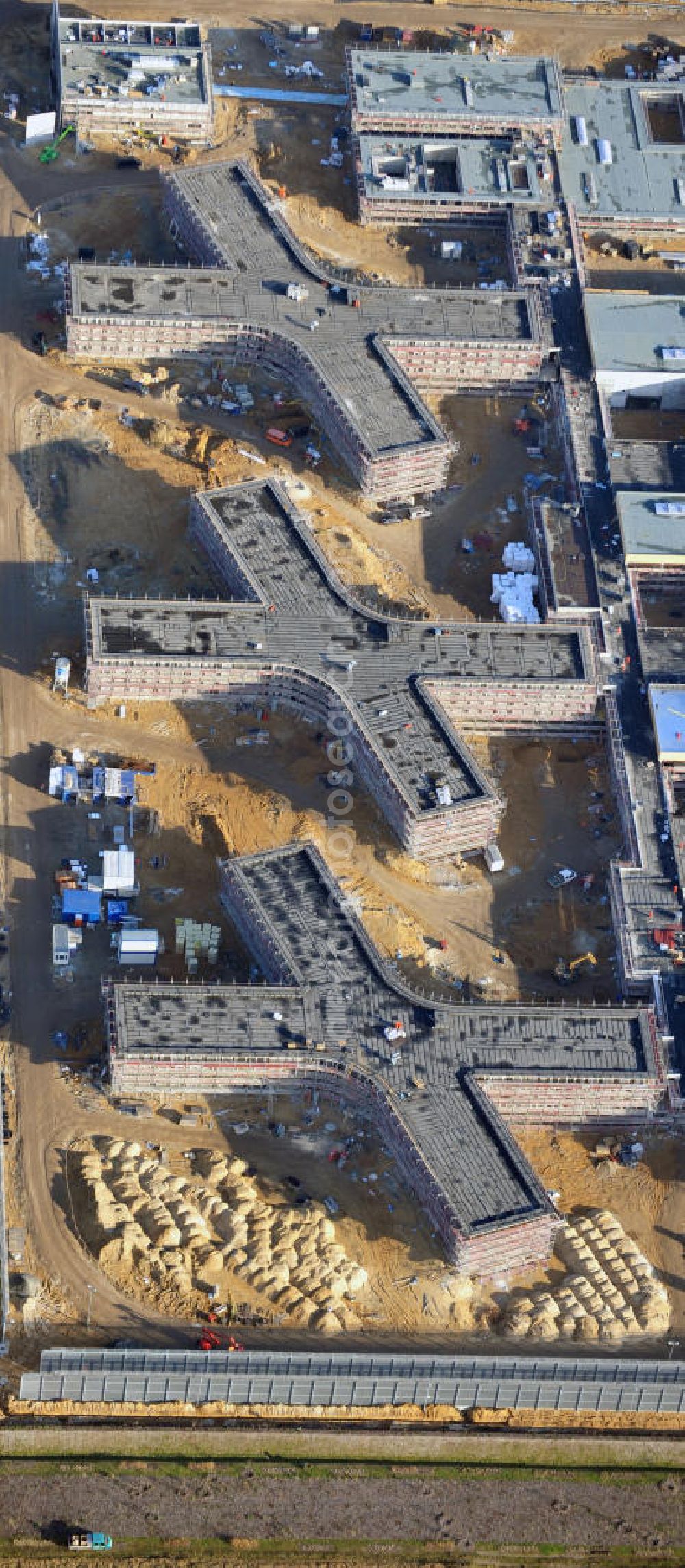 Aerial photograph Großbeeren - Baustelle vom Neubau der Justizvollzugsanstalt JVA Heidering Großbeeren im Landkreis Teltow-Fläming in Brandenburg durch die Senatsverwaltung für Justiz. Der Neubau der Haftanstalt in Großbeeren wird nur elektrisch und mit einem Erdwall gesichert statt mit einer koventionellen Gefängnismauer. Die Projektentwurf erfolgte durch das Architekturbüro Hohensinn. Ausführende Baufirmen sind die Bleck & Söhne Hoch- und Tiefbau GmbH & Co. KG, sowie die Schälerbau Berlin. Construction site of the new penal institution Heidering Grossbeeren.