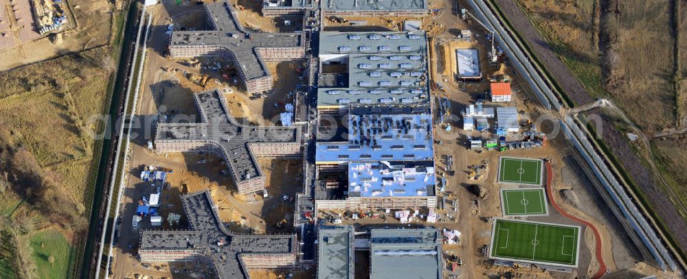 Aerial photograph Großbeeren - Baustelle vom Neubau der Justizvollzugsanstalt JVA Heidering Großbeeren im Landkreis Teltow-Fläming in Brandenburg durch die Senatsverwaltung für Justiz. Der Neubau der Haftanstalt in Großbeeren wird nur elektrisch und mit einem Erdwall gesichert statt mit einer koventionellen Gefängnismauer. Die Projektentwurf erfolgte durch das Architekturbüro Hohensinn. Ausführende Baufirmen sind die Bleck & Söhne Hoch- und Tiefbau GmbH & Co. KG, sowie die Schälerbau Berlin. Construction site of the new penal institution Heidering Grossbeeren.