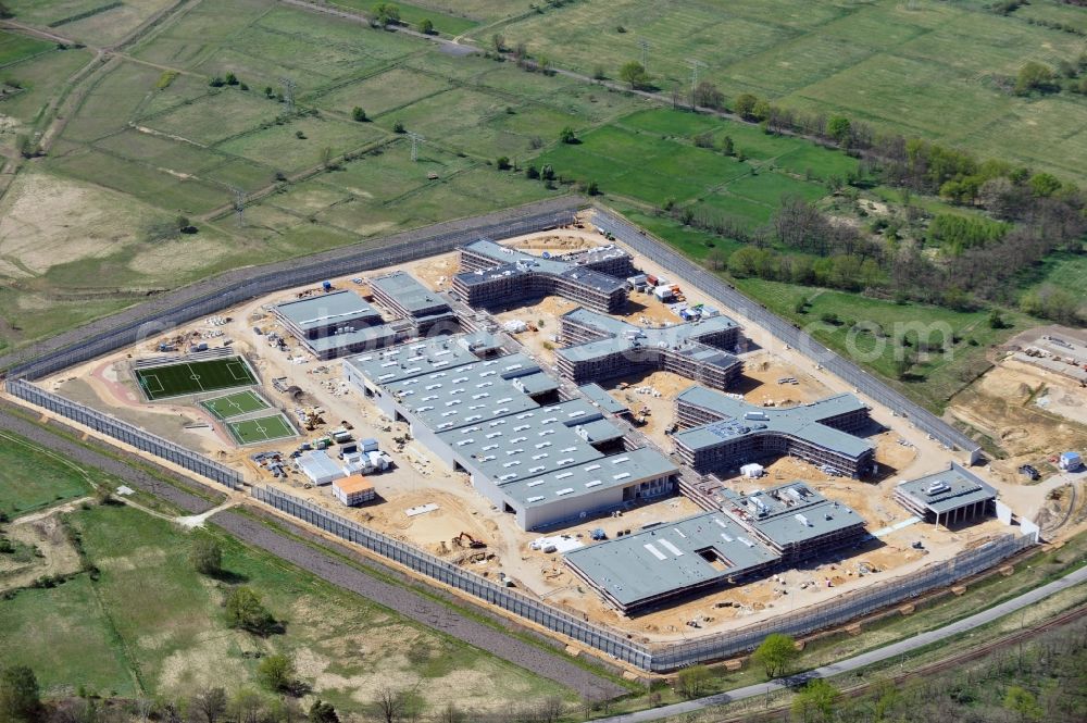 Großbeeren from the bird's eye view: Baustelle vom Neubau der Justizvollzugsanstalt JVA Heidering Großbeeren im Landkreis Teltow-Fläming in Brandenburg durch die Senatsverwaltung für Justiz. Der Neubau der Haftanstalt in Großbeeren wird nur elektrisch und mit einem Erdwall gesichert statt mit einer koventionellen Gefängnismauer. Die Projektentwurf erfolgte durch das Architekturbüro Hohensinn. Ausführende Baufirmen sind die Bleck & Söhne Hoch- und Tiefbau GmbH & Co. KG, sowie die Schälerbau Berlin. Construction site of the new penal institution Heidering Grossbeeren.