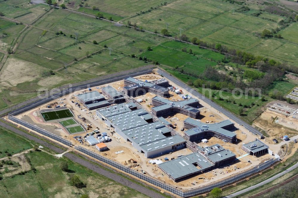 Aerial photograph Großbeeren - Baustelle vom Neubau der Justizvollzugsanstalt JVA Heidering Großbeeren im Landkreis Teltow-Fläming in Brandenburg durch die Senatsverwaltung für Justiz. Der Neubau der Haftanstalt in Großbeeren wird nur elektrisch und mit einem Erdwall gesichert statt mit einer koventionellen Gefängnismauer. Die Projektentwurf erfolgte durch das Architekturbüro Hohensinn. Ausführende Baufirmen sind die Bleck & Söhne Hoch- und Tiefbau GmbH & Co. KG, sowie die Schälerbau Berlin. Construction site of the new penal institution Heidering Grossbeeren.