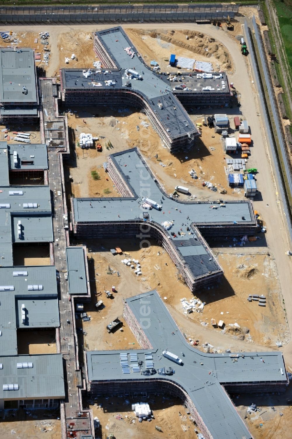 Aerial image Großbeeren - Baustelle vom Neubau der Justizvollzugsanstalt JVA Heidering Großbeeren im Landkreis Teltow-Fläming in Brandenburg durch die Senatsverwaltung für Justiz. Der Neubau der Haftanstalt in Großbeeren wird nur elektrisch und mit einem Erdwall gesichert statt mit einer koventionellen Gefängnismauer. Die Projektentwurf erfolgte durch das Architekturbüro Hohensinn. Ausführende Baufirmen sind die Bleck & Söhne Hoch- und Tiefbau GmbH & Co. KG, sowie die Schälerbau Berlin. Construction site of the new penal institution Heidering Grossbeeren.