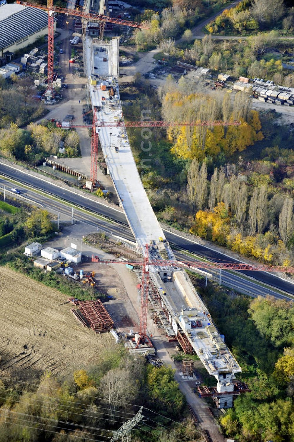 Aerial photograph Rattmannsdorf - Blick auf die Vorschub- Bauarbeiten an der Saale-Elster-Talbrücke zwischen Ammendorf und Schkopau. Das Beton- Viadukt mit insgesamt 8, 5 Kilometern Länge wird teilweise mit großen Baugerüsten in so genannter Vor-Kopf-Bauweise errichtet. Die ICE - Neubaustrecke im Projekt VDE 8 Nürnberg-Berlin der Deutschen Bahn und der DEGES soll 2015 in Betrieb gehen und wird das bisher längste Brückenbauwerk Deutschlands sein. Bauausführende Firmen sind die Hochtief Construction AG, Adam Hörnig, Gerdum und Breuer; Franki Grundbau; Doka Schalungstechniker; BBV Vorspanntechnik; Röro Traggerüstsysteme; Oevermann Hoch- und Tiefbau, Teupe & Söhne Gerüstbau GmbH, Alpine Bau, Kann Baustoffe und Arcelormittal. Die Bauüberwachung erfolgt durch das Ingenieurbüro Schüßler Plan. View of the construction of the Saale-Elster Viaduct between Ammandorf and Schkopau in Saxony Anhalt.