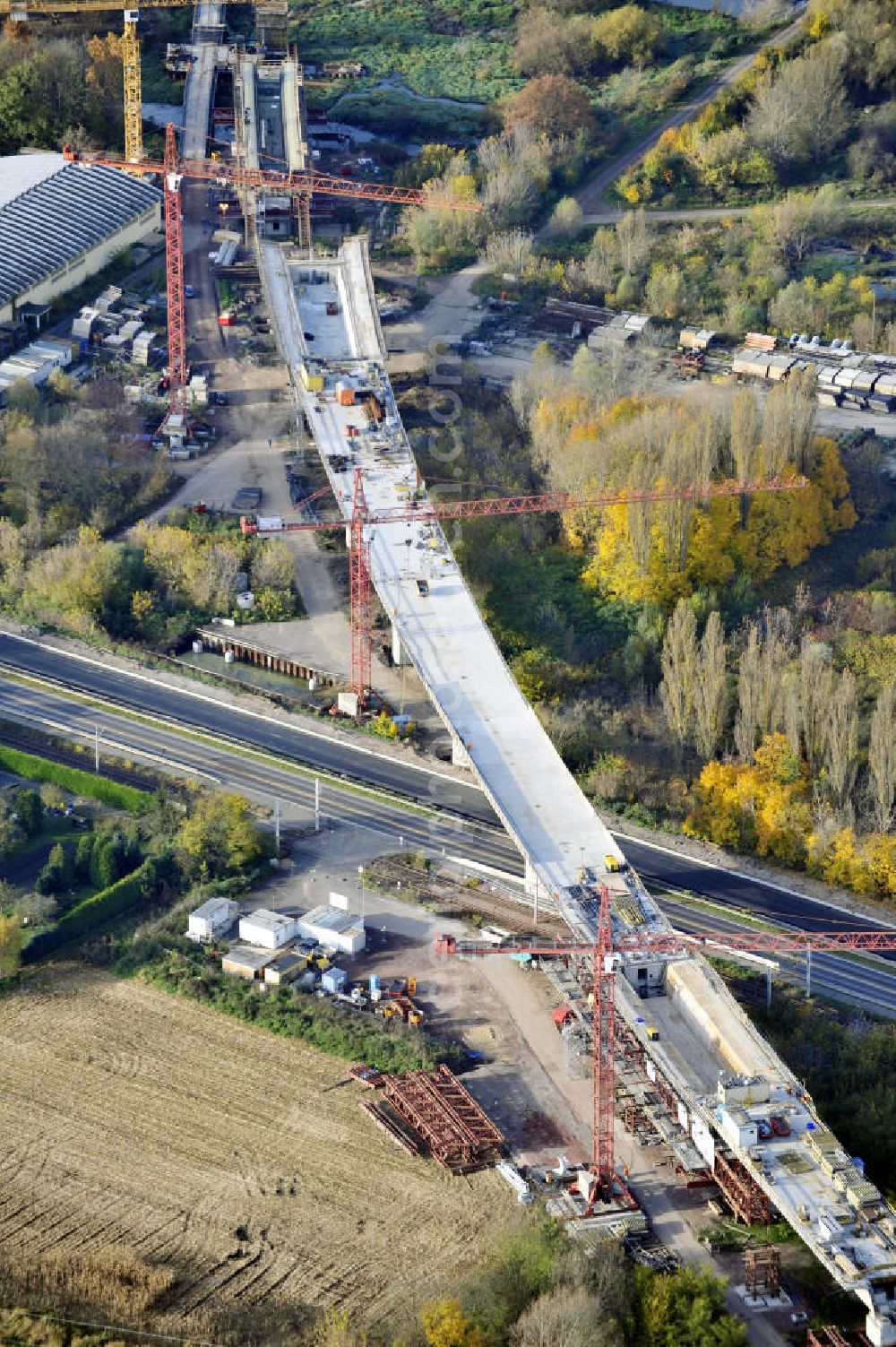 Rattmannsdorf from the bird's eye view: Blick auf die Vorschub- Bauarbeiten an der Saale-Elster-Talbrücke zwischen Ammendorf und Schkopau. Das Beton- Viadukt mit insgesamt 8, 5 Kilometern Länge wird teilweise mit großen Baugerüsten in so genannter Vor-Kopf-Bauweise errichtet. Die ICE - Neubaustrecke im Projekt VDE 8 Nürnberg-Berlin der Deutschen Bahn und der DEGES soll 2015 in Betrieb gehen und wird das bisher längste Brückenbauwerk Deutschlands sein. Bauausführende Firmen sind die Hochtief Construction AG, Adam Hörnig, Gerdum und Breuer; Franki Grundbau; Doka Schalungstechniker; BBV Vorspanntechnik; Röro Traggerüstsysteme; Oevermann Hoch- und Tiefbau, Teupe & Söhne Gerüstbau GmbH, Alpine Bau, Kann Baustoffe und Arcelormittal. Die Bauüberwachung erfolgt durch das Ingenieurbüro Schüßler Plan. View of the construction of the Saale-Elster Viaduct between Ammandorf and Schkopau in Saxony Anhalt.