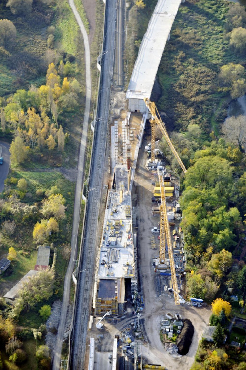 Aerial image Rattmannsdorf - Blick auf die Vorschub- Bauarbeiten an der Saale-Elster-Talbrücke zwischen Ammendorf und Schkopau. Das Beton- Viadukt mit insgesamt 8, 5 Kilometern Länge wird teilweise mit großen Baugerüsten in so genannter Vor-Kopf-Bauweise errichtet. Die ICE - Neubaustrecke im Projekt VDE 8 Nürnberg-Berlin der Deutschen Bahn und der DEGES soll 2015 in Betrieb gehen und wird das bisher längste Brückenbauwerk Deutschlands sein. Bauausführende Firmen sind die Hochtief Construction AG, Adam Hörnig, Gerdum und Breuer; Franki Grundbau; Doka Schalungstechniker; BBV Vorspanntechnik; Röro Traggerüstsysteme; Oevermann Hoch- und Tiefbau, Teupe & Söhne Gerüstbau GmbH, Alpine Bau, Kann Baustoffe und Arcelormittal. Die Bauüberwachung erfolgt durch das Ingenieurbüro Schüßler Plan. View of the construction of the Saale-Elster Viaduct between Ammandorf and Schkopau in Saxony Anhalt.