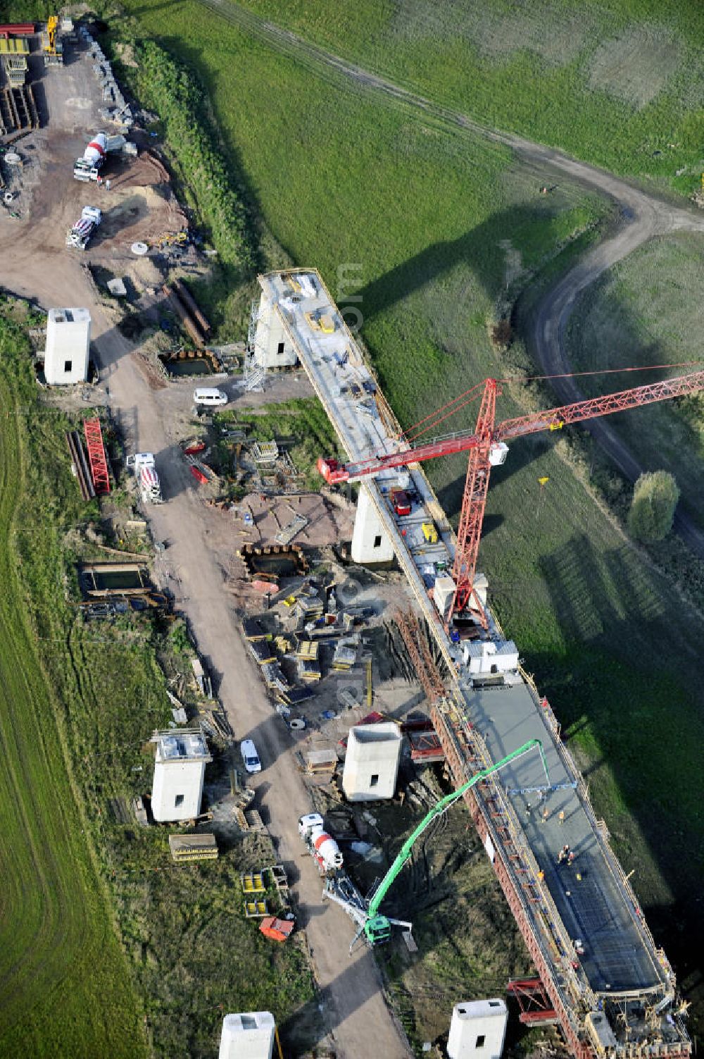 Aerial photograph Rattmannsdorf - Blick auf die Vorschub- Bauarbeiten an der Saale-Elster-Talbrücke zwischen Ammendorf und Schkopau. Das Beton- Viadukt mit insgesamt 8, 5 Kilometern Länge wird teilweise mit großen Baugerüsten in so genannter Vor-Kopf-Bauweise errichtet. Die ICE - Neubaustrecke im Projekt VDE 8 Nürnberg-Berlin der Deutschen Bahn und der DEGES soll 2015 in Betrieb gehen und wird das bisher längste Brückenbauwerk Deutschlands sein. Bauausführende Firmen sind die Hochtief Construction AG, Adam Hörnig, Gerdum und Breuer; Franki Grundbau; Doka Schalungstechniker; BBV Vorspanntechnik; Röro Traggerüstsysteme; Oevermann Hoch- und Tiefbau, Teupe & Söhne Gerüstbau GmbH, Alpine Bau, Kann Baustoffe und Arcelormittal. Die Bauüberwachung erfolgt durch das Ingenieurbüro Schüßler Plan. View of the construction of the Saale-Elster Viaduct between Ammandorf and Schkopau in Saxony Anhalt.