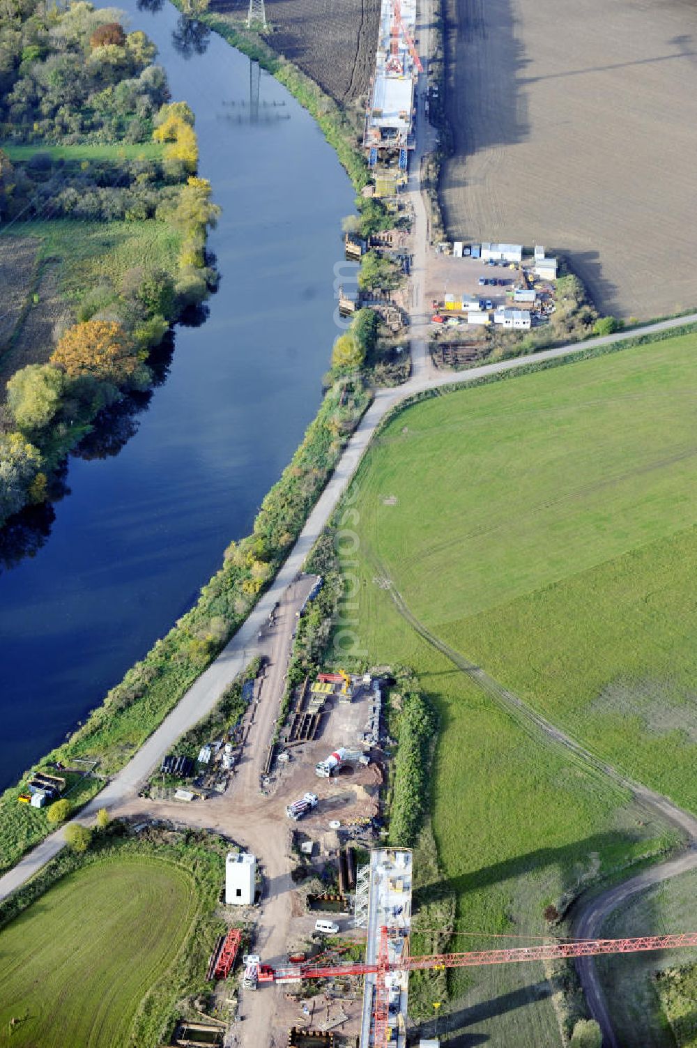 Rattmannsdorf from above - Blick auf die Vorschub- Bauarbeiten an der Saale-Elster-Talbrücke zwischen Ammendorf und Schkopau. Das Beton- Viadukt mit insgesamt 8, 5 Kilometern Länge wird teilweise mit großen Baugerüsten in so genannter Vor-Kopf-Bauweise errichtet. Die ICE - Neubaustrecke im Projekt VDE 8 Nürnberg-Berlin der Deutschen Bahn und der DEGES soll 2015 in Betrieb gehen und wird das bisher längste Brückenbauwerk Deutschlands sein. Bauausführende Firmen sind die Hochtief Construction AG, Adam Hörnig, Gerdum und Breuer; Franki Grundbau; Doka Schalungstechniker; BBV Vorspanntechnik; Röro Traggerüstsysteme; Oevermann Hoch- und Tiefbau, Teupe & Söhne Gerüstbau GmbH, Alpine Bau, Kann Baustoffe und Arcelormittal. Die Bauüberwachung erfolgt durch das Ingenieurbüro Schüßler Plan. View of the construction of the Saale-Elster Viaduct between Ammandorf and Schkopau in Saxony Anhalt.