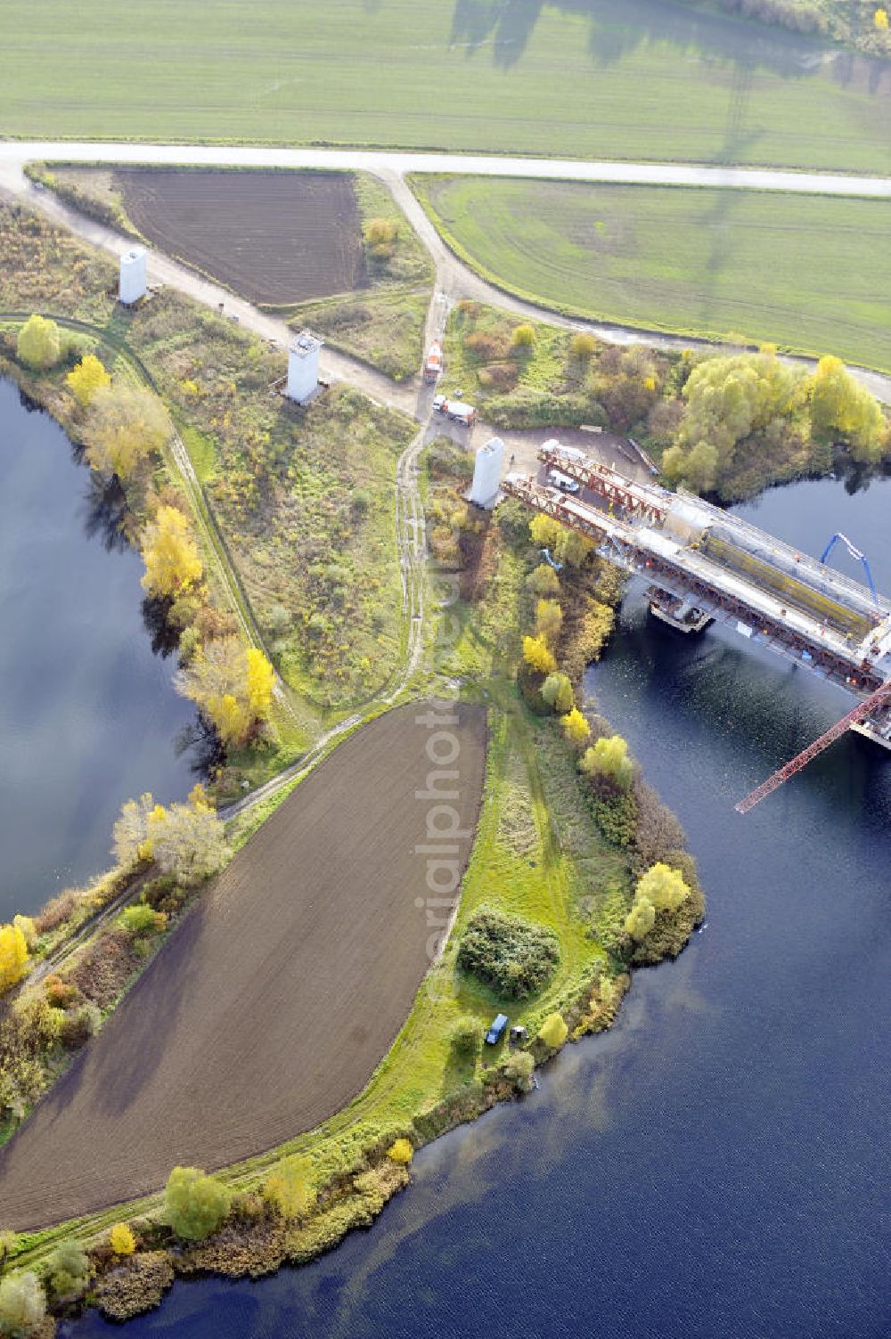 Aerial photograph Rattmannsdorf - Blick auf die Vorschub- Bauarbeiten an der Saale-Elster-Talbrücke zwischen Ammendorf und Schkopau. Das Beton- Viadukt mit insgesamt 8, 5 Kilometern Länge wird teilweise mit großen Baugerüsten in so genannter Vor-Kopf-Bauweise errichtet. Die ICE - Neubaustrecke im Projekt VDE 8 Nürnberg-Berlin der Deutschen Bahn und der DEGES soll 2015 in Betrieb gehen und wird das bisher längste Brückenbauwerk Deutschlands sein. Bauausführende Firmen sind die Hochtief Construction AG, Adam Hörnig, Gerdum und Breuer; Franki Grundbau; Doka Schalungstechniker; BBV Vorspanntechnik; Röro Traggerüstsysteme; Oevermann Hoch- und Tiefbau, Teupe & Söhne Gerüstbau GmbH, Alpine Bau, Kann Baustoffe und Arcelormittal. Die Bauüberwachung erfolgt durch das Ingenieurbüro Schüßler Plan. View of the construction of the Saale-Elster Viaduct between Ammandorf and Schkopau in Saxony Anhalt.