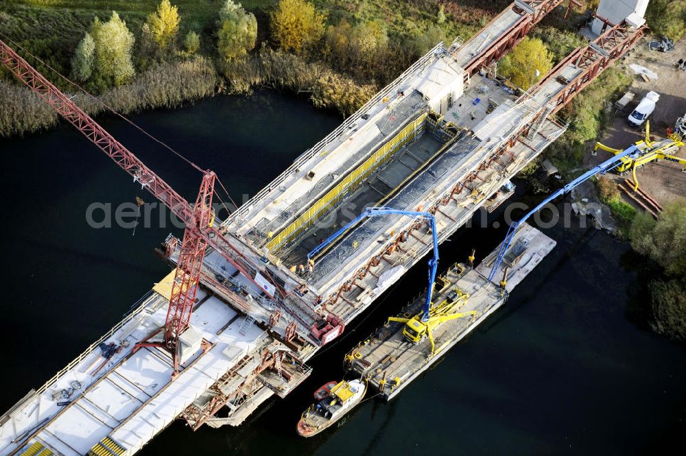 Aerial photograph Rattmannsdorf - Blick auf die Vorschub- Bauarbeiten an der Saale-Elster-Talbrücke zwischen Ammendorf und Schkopau. Das Beton- Viadukt mit insgesamt 8, 5 Kilometern Länge wird teilweise mit großen Baugerüsten in so genannter Vor-Kopf-Bauweise errichtet. Die ICE - Neubaustrecke im Projekt VDE 8 Nürnberg-Berlin der Deutschen Bahn und der DEGES soll 2015 in Betrieb gehen und wird das bisher längste Brückenbauwerk Deutschlands sein. Bauausführende Firmen sind die Hochtief Construction AG, Adam Hörnig, Gerdum und Breuer; Franki Grundbau; Doka Schalungstechniker; BBV Vorspanntechnik; Röro Traggerüstsysteme; Oevermann Hoch- und Tiefbau, Teupe & Söhne Gerüstbau GmbH, Alpine Bau, Kann Baustoffe und Arcelormittal. Die Bauüberwachung erfolgt durch das Ingenieurbüro Schüßler Plan. View of the construction of the Saale-Elster Viaduct between Ammandorf and Schkopau in Saxony Anhalt.