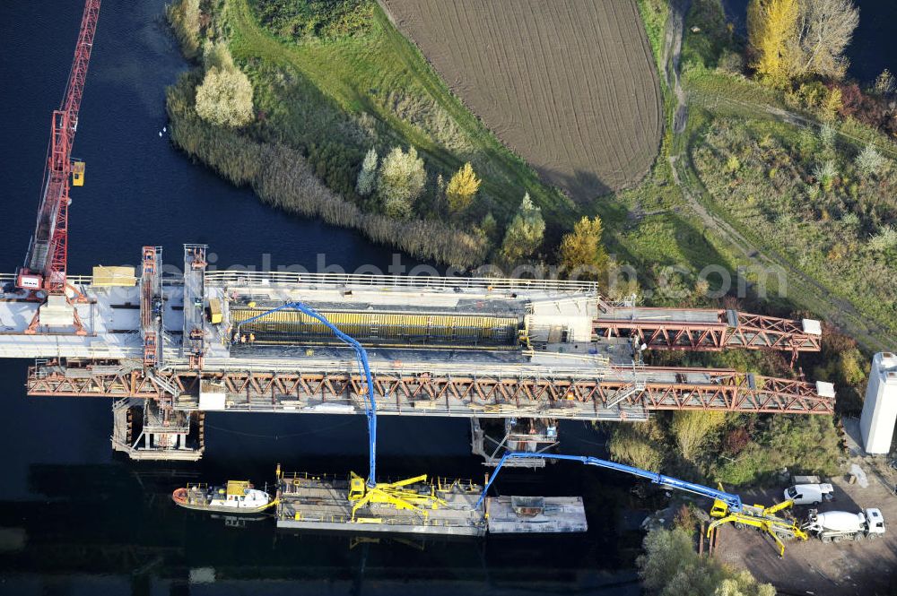 Aerial image Rattmannsdorf - Blick auf die Vorschub- Bauarbeiten an der Saale-Elster-Talbrücke zwischen Ammendorf und Schkopau. Das Beton- Viadukt mit insgesamt 8, 5 Kilometern Länge wird teilweise mit großen Baugerüsten in so genannter Vor-Kopf-Bauweise errichtet. Die ICE - Neubaustrecke im Projekt VDE 8 Nürnberg-Berlin der Deutschen Bahn und der DEGES soll 2015 in Betrieb gehen und wird das bisher längste Brückenbauwerk Deutschlands sein. Bauausführende Firmen sind die Hochtief Construction AG, Adam Hörnig, Gerdum und Breuer; Franki Grundbau; Doka Schalungstechniker; BBV Vorspanntechnik; Röro Traggerüstsysteme; Oevermann Hoch- und Tiefbau, Teupe & Söhne Gerüstbau GmbH, Alpine Bau, Kann Baustoffe und Arcelormittal. Die Bauüberwachung erfolgt durch das Ingenieurbüro Schüßler Plan. View of the construction of the Saale-Elster Viaduct between Ammandorf and Schkopau in Saxony Anhalt.