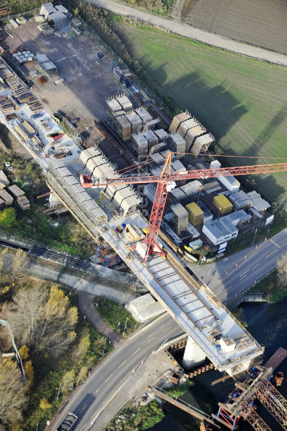 Rattmannsdorf from the bird's eye view: Blick auf die Vorschub- Bauarbeiten an der Saale-Elster-Talbrücke zwischen Ammendorf und Schkopau. Das Beton- Viadukt mit insgesamt 8, 5 Kilometern Länge wird teilweise mit großen Baugerüsten in so genannter Vor-Kopf-Bauweise errichtet. Die ICE - Neubaustrecke im Projekt VDE 8 Nürnberg-Berlin der Deutschen Bahn und der DEGES soll 2015 in Betrieb gehen und wird das bisher längste Brückenbauwerk Deutschlands sein. Bauausführende Firmen sind die Hochtief Construction AG, Adam Hörnig, Gerdum und Breuer; Franki Grundbau; Doka Schalungstechniker; BBV Vorspanntechnik; Röro Traggerüstsysteme; Oevermann Hoch- und Tiefbau, Teupe & Söhne Gerüstbau GmbH, Alpine Bau, Kann Baustoffe und Arcelormittal. Die Bauüberwachung erfolgt durch das Ingenieurbüro Schüßler Plan. View of the construction of the Saale-Elster Viaduct between Ammandorf and Schkopau in Saxony Anhalt.