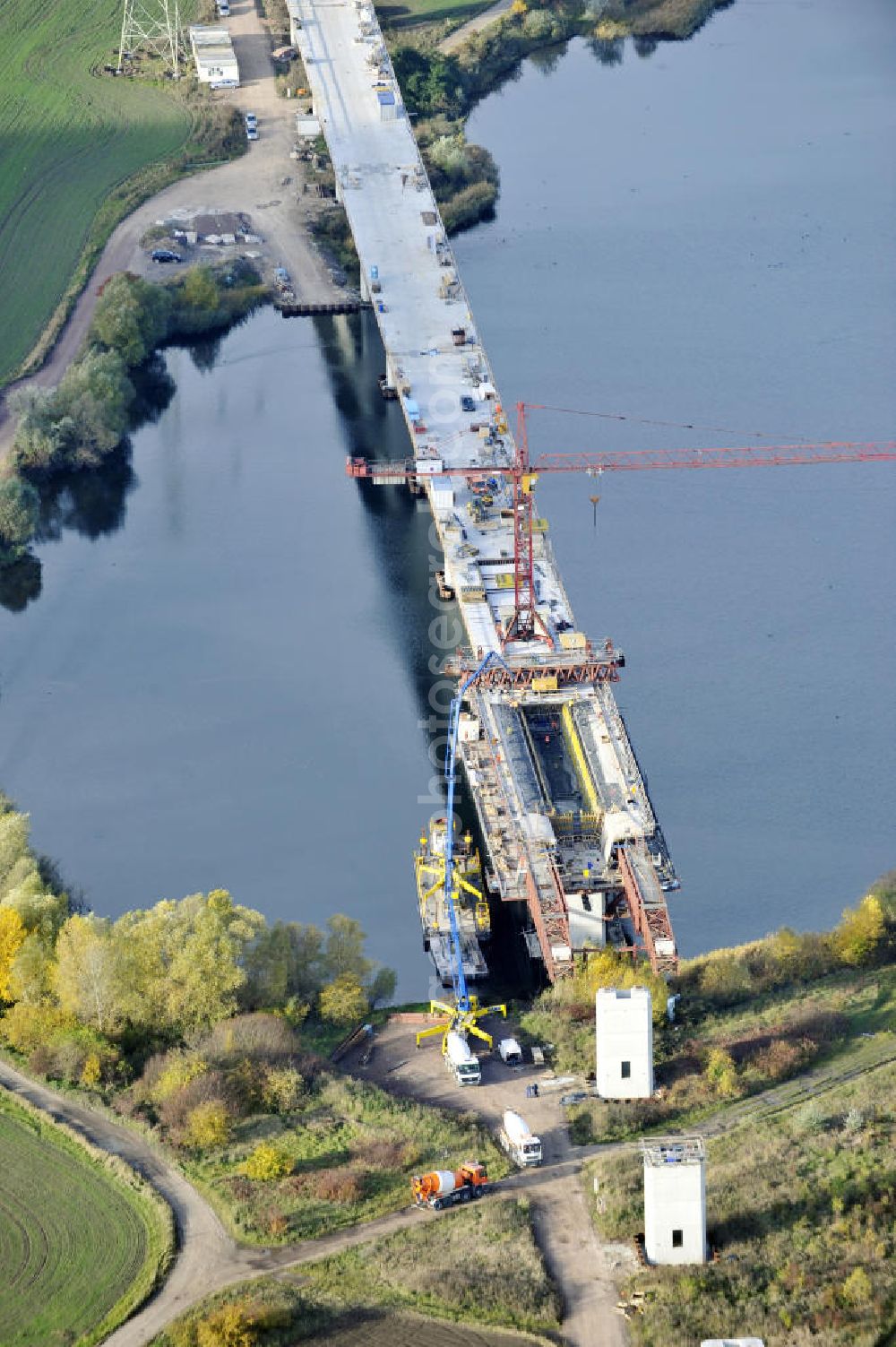 Aerial image Rattmannsdorf - Blick auf die Vorschub- Bauarbeiten an der Saale-Elster-Talbrücke zwischen Ammendorf und Schkopau. Das Beton- Viadukt mit insgesamt 8, 5 Kilometern Länge wird teilweise mit großen Baugerüsten in so genannter Vor-Kopf-Bauweise errichtet. Die ICE - Neubaustrecke im Projekt VDE 8 Nürnberg-Berlin der Deutschen Bahn und der DEGES soll 2015 in Betrieb gehen und wird das bisher längste Brückenbauwerk Deutschlands sein. Bauausführende Firmen sind die Hochtief Construction AG, Adam Hörnig, Gerdum und Breuer; Franki Grundbau; Doka Schalungstechniker; BBV Vorspanntechnik; Röro Traggerüstsysteme; Oevermann Hoch- und Tiefbau, Teupe & Söhne Gerüstbau GmbH, Alpine Bau, Kann Baustoffe und Arcelormittal. Die Bauüberwachung erfolgt durch das Ingenieurbüro Schüßler Plan. View of the construction of the Saale-Elster Viaduct between Ammandorf and Schkopau in Saxony Anhalt.