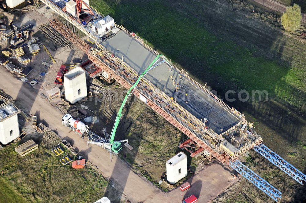 Rattmannsdorf from the bird's eye view: Blick auf die Vorschub- Bauarbeiten an der Saale-Elster-Talbrücke zwischen Ammendorf und Schkopau. Das Beton- Viadukt mit insgesamt 8, 5 Kilometern Länge wird teilweise mit großen Baugerüsten in so genannter Vor-Kopf-Bauweise errichtet. Die ICE - Neubaustrecke im Projekt VDE 8 Nürnberg-Berlin der Deutschen Bahn und der DEGES soll 2015 in Betrieb gehen und wird das bisher längste Brückenbauwerk Deutschlands sein. Bauausführende Firmen sind die Hochtief Construction AG, Adam Hörnig, Gerdum und Breuer; Franki Grundbau; Doka Schalungstechniker; BBV Vorspanntechnik; Röro Traggerüstsysteme; Oevermann Hoch- und Tiefbau, Teupe & Söhne Gerüstbau GmbH, Alpine Bau, Kann Baustoffe und Arcelormittal. Die Bauüberwachung erfolgt durch das Ingenieurbüro Schüßler Plan. View of the construction of the Saale-Elster Viaduct between Ammandorf and Schkopau in Saxony Anhalt.